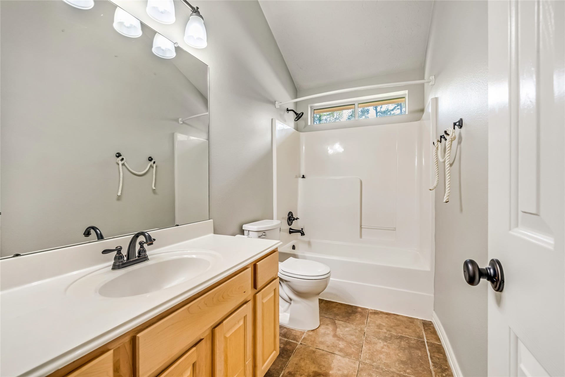 914 Mesquite Drive, Magnolia, TX 77354 Secondary bathroom has lots of storage space and a window in the shower/tub combo as well as tile flooring