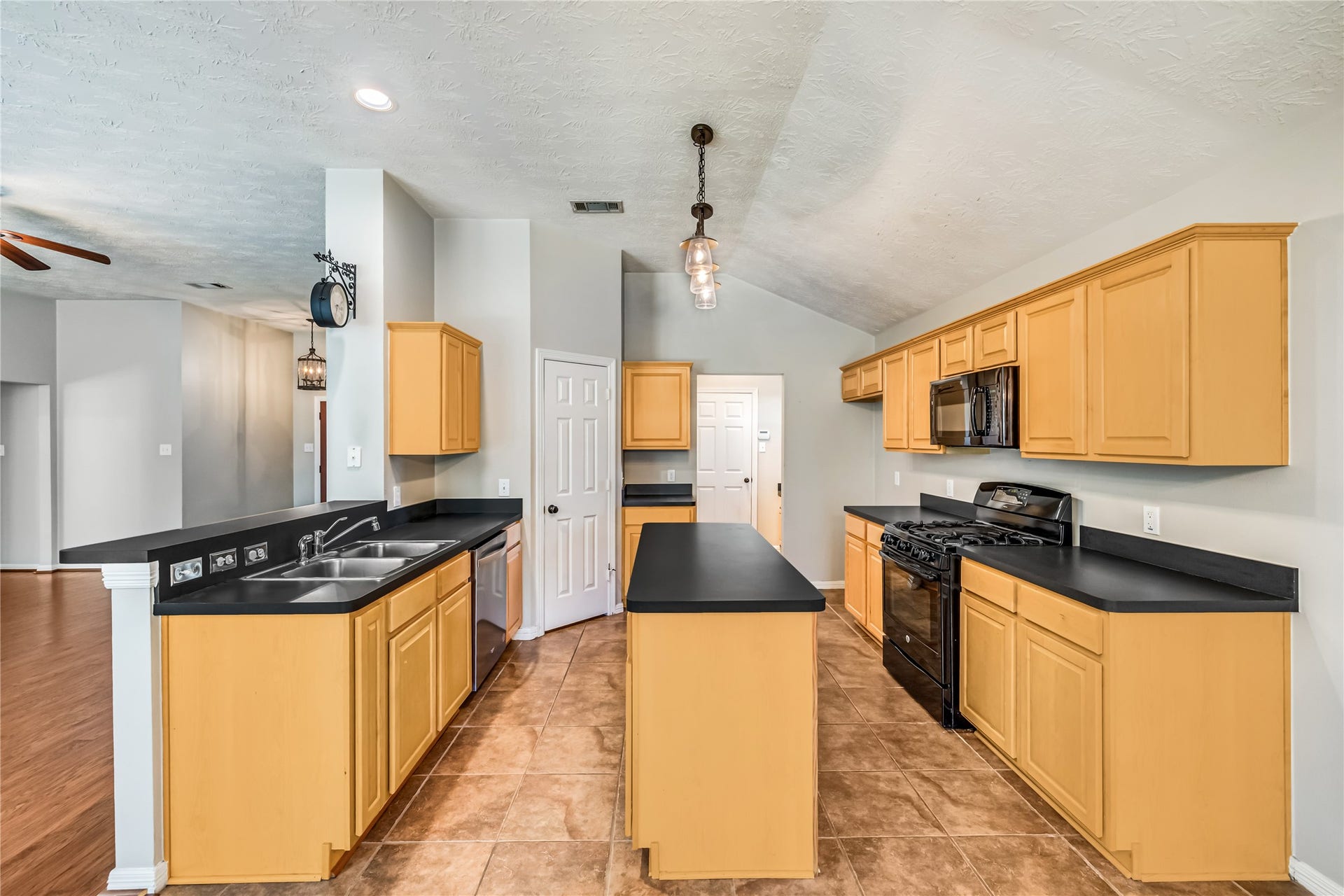 914 Mesquite Drive, Magnolia, TX 77354 Clean, sturdy, proven kitchen to create delicious meals has a vaulted ceiling and is easily accessible to/from the garage.(Hanging Clock Excluded)