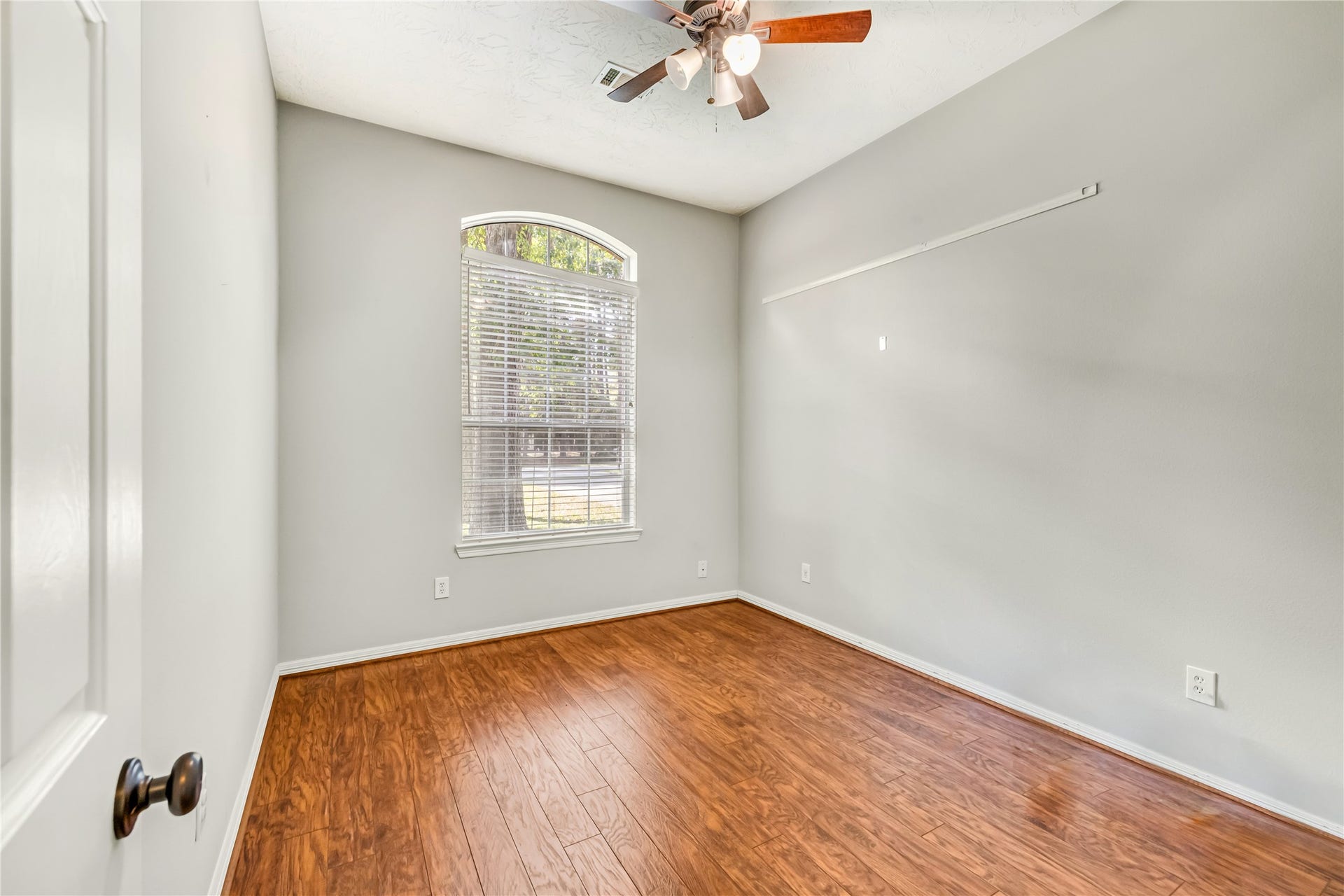914 Mesquite Drive, Magnolia, TX 77354 Bedroom 3 has a ceiling fan and an arched window.