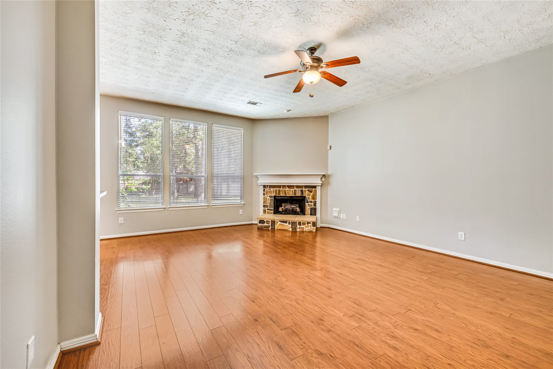 914 Mesquite Drive, Magnolia, TX 77354 The living room has a stone fireplace and ceiling fan for your comfort and enjoyment