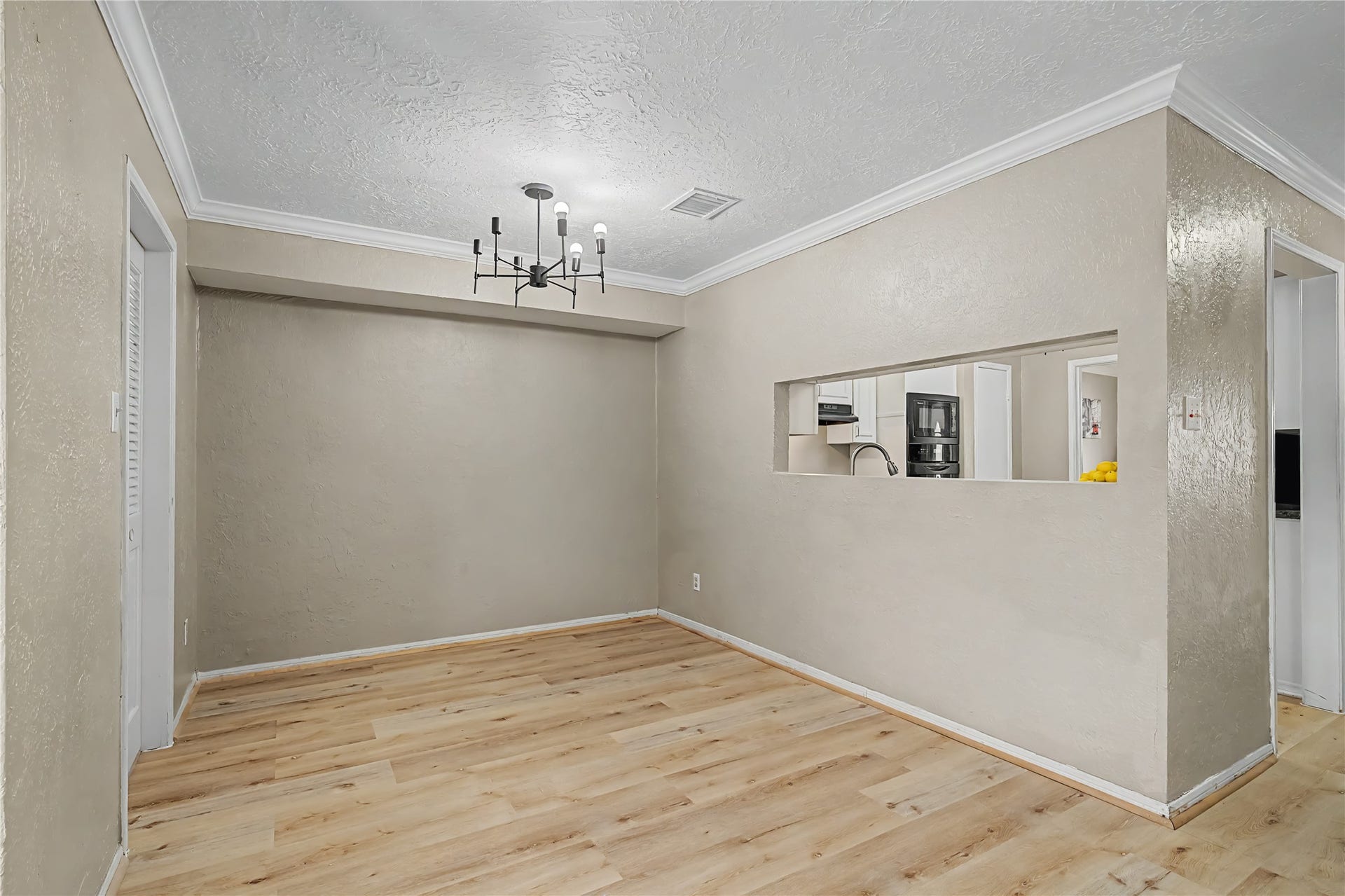 794 Thicket Lane, Houston, TX 77079 Open breakfast room with wood-look flooring, crown molding, and a pass-through opening to the kitchen.