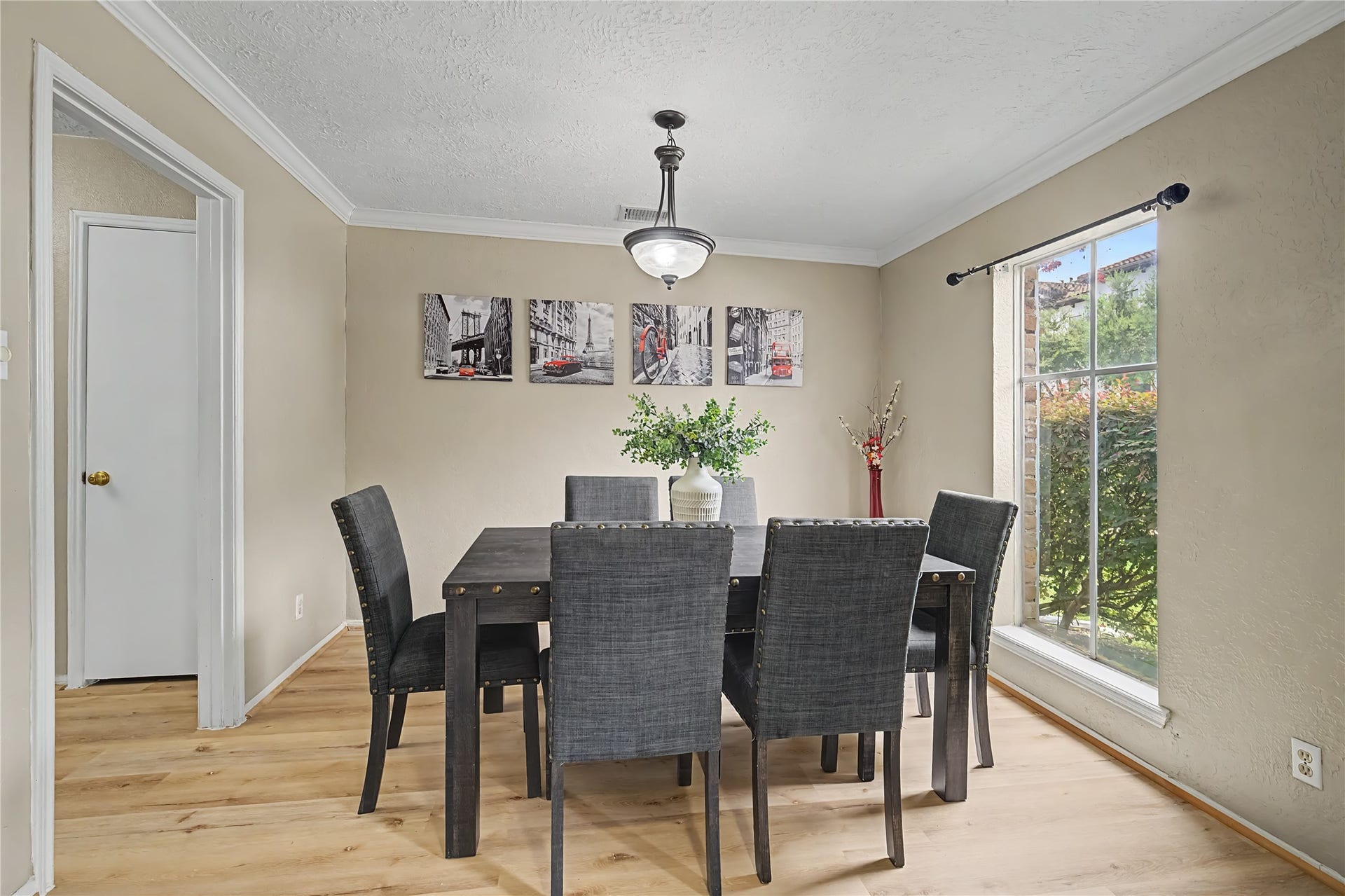 794 Thicket Lane, Houston, TX 77079 Spacious dining area with wood-look flooring, crown molding, overhead lighting, and a large window.