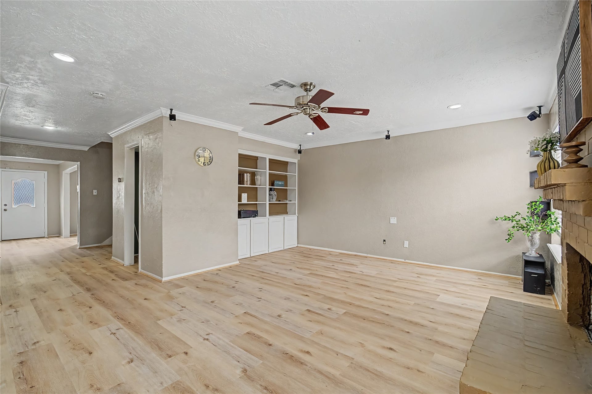 794 Thicket Lane, Houston, TX 77079 Spacious living area with wood-look flooring, recessed lighting, ceiling fan, and a brick fireplace.