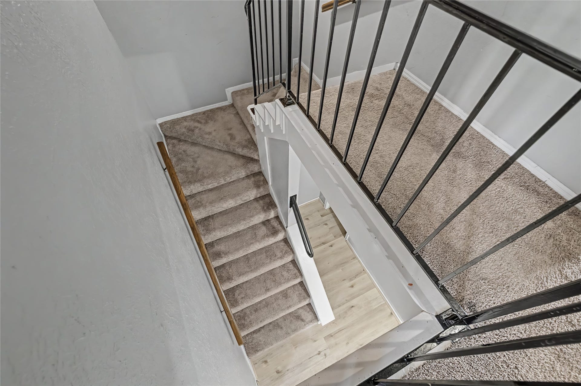 794 Thicket Lane, Houston, TX 77079 Carpeted staircase with metal railings connecting the upper and lower levels.