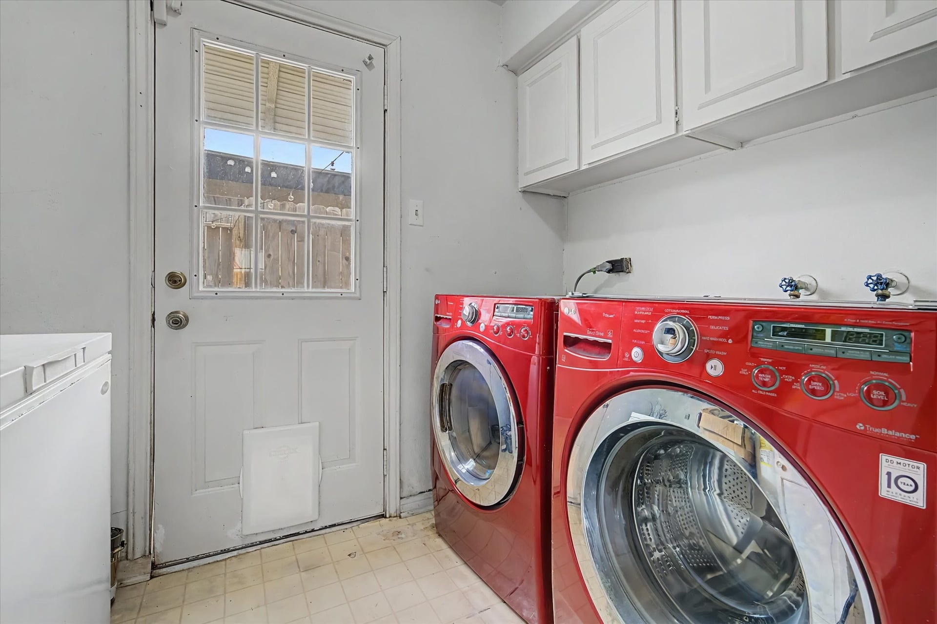 794 Thicket Lane, Houston, TX 77079 Dedicated laundry area with overhead cabinetry, washer and dryer connections, and exterior access.