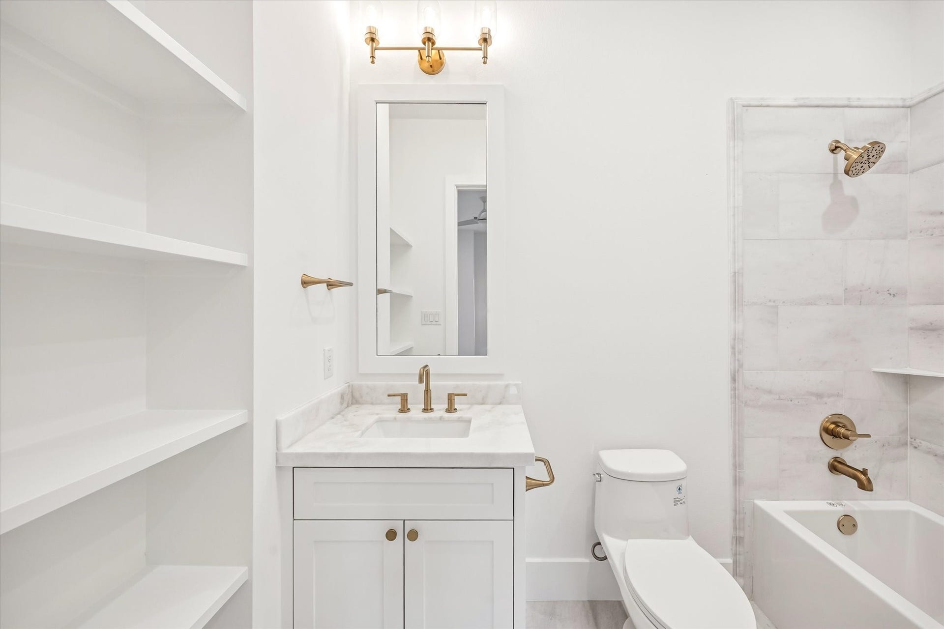 320 W 32nd Street, Houston, TX 77018 Built in shelving and a streamlined vanity maximize storage while keeping the space feeling light and open. Classic tile, stone surfaces, and warm metal fixtures deliver a clean, durable bath designed for everyday use.**Previous build by Arch Angelo**