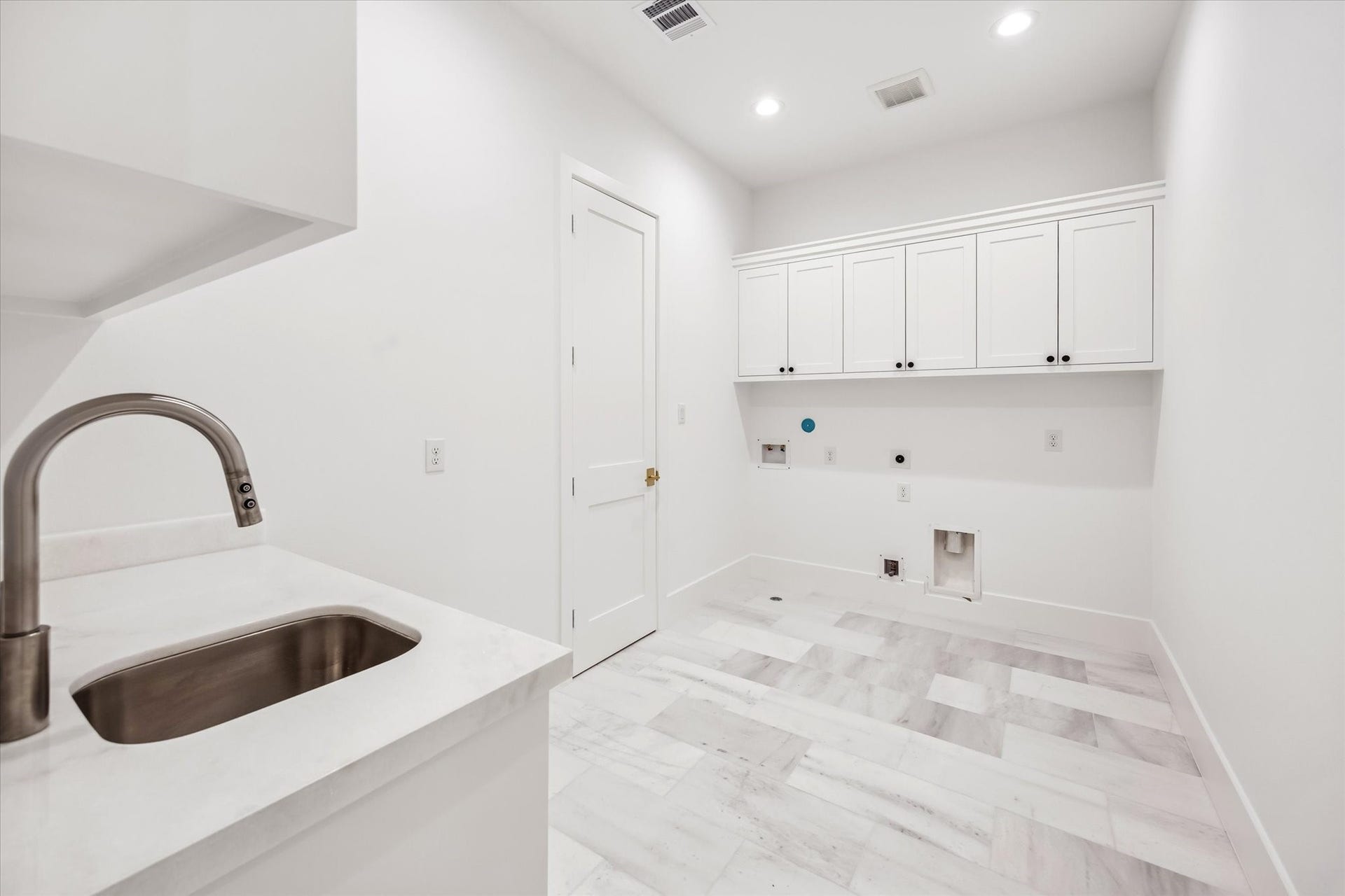 320 W 32nd Street, Houston, TX 77018 Generous utility space designed for everyday efficiency, featuring a deep sink, stone countertops, and upper cabinetry for concealed storage. Layout allows room for full size appliances while keeping tasks organized and out of sight.**Previous build by Arch Angelo**