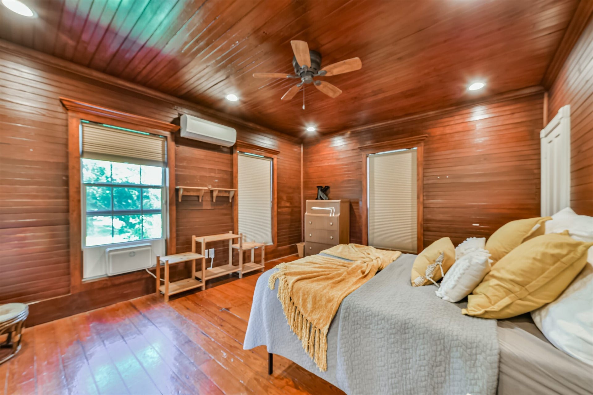 503 W Blum Street, Alvin, TX 77511 Upstairs primary bedroom wrapped in warm wood creates a cozy retreat with loads of historic personality.