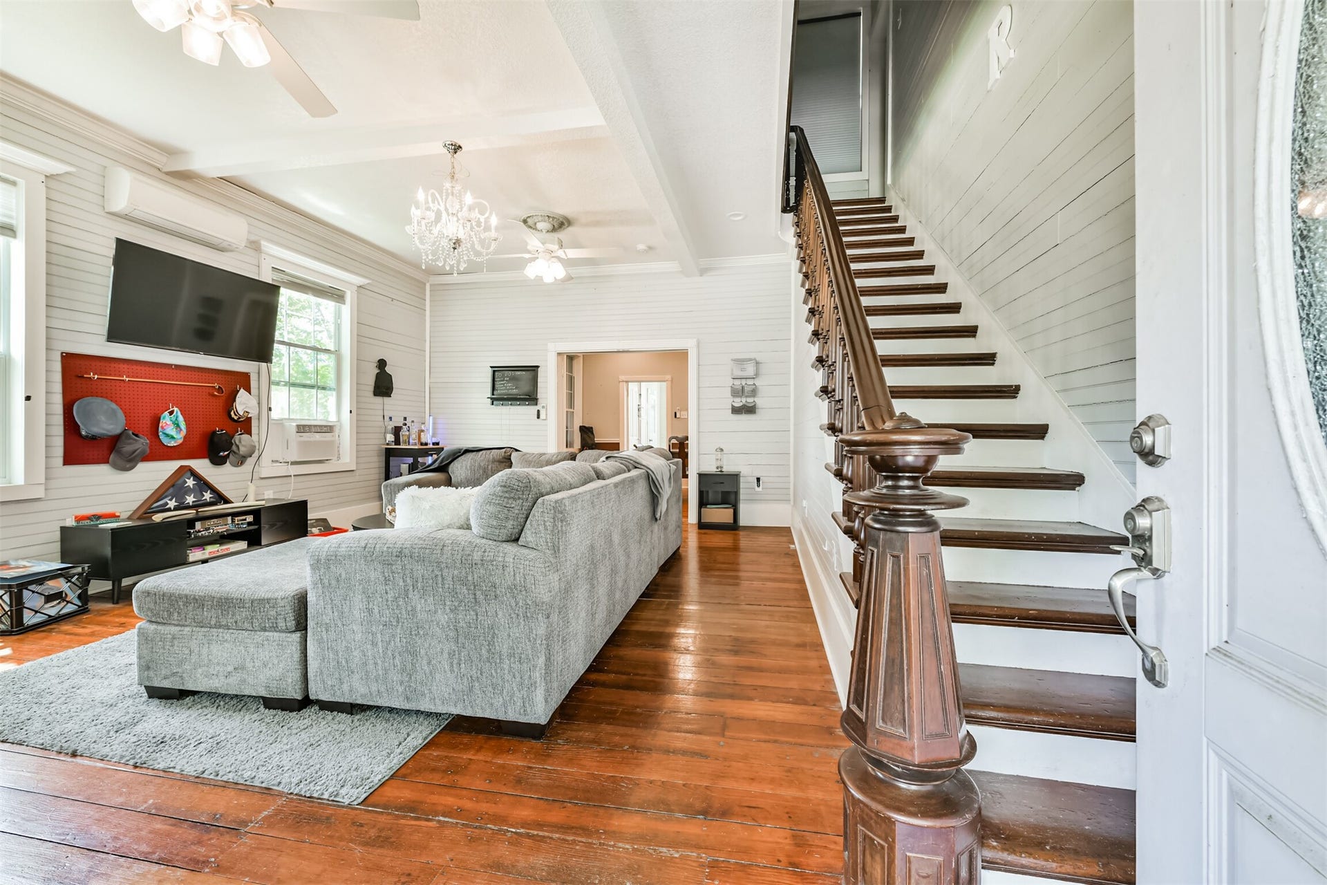 503 W Blum Street, Alvin, TX 77511 Original hardwood floors and the striking dark walnut staircase immediately steal the show.