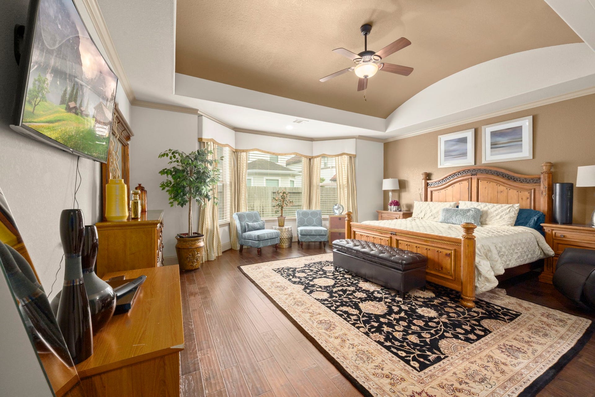 5103 Jackson Ponds Court, Sugar Land, TX 77479 This spacious primary bedroom features elegant hardwood floors, a vaulted ceiling, and ample natural light from large windows.