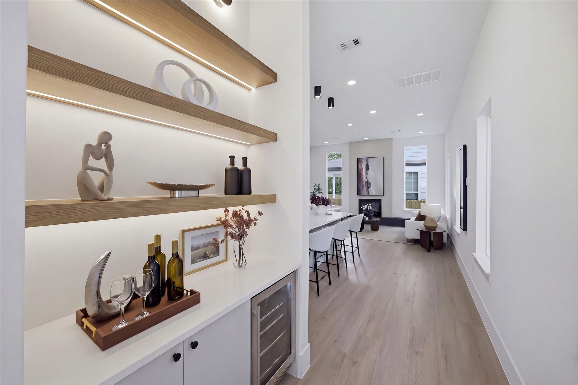1004 E 35th Street, Houston, TX 77022 Sleek and modern hallway leading to an open-concept living area, featuring stylish built-in shelving and a wine fridge