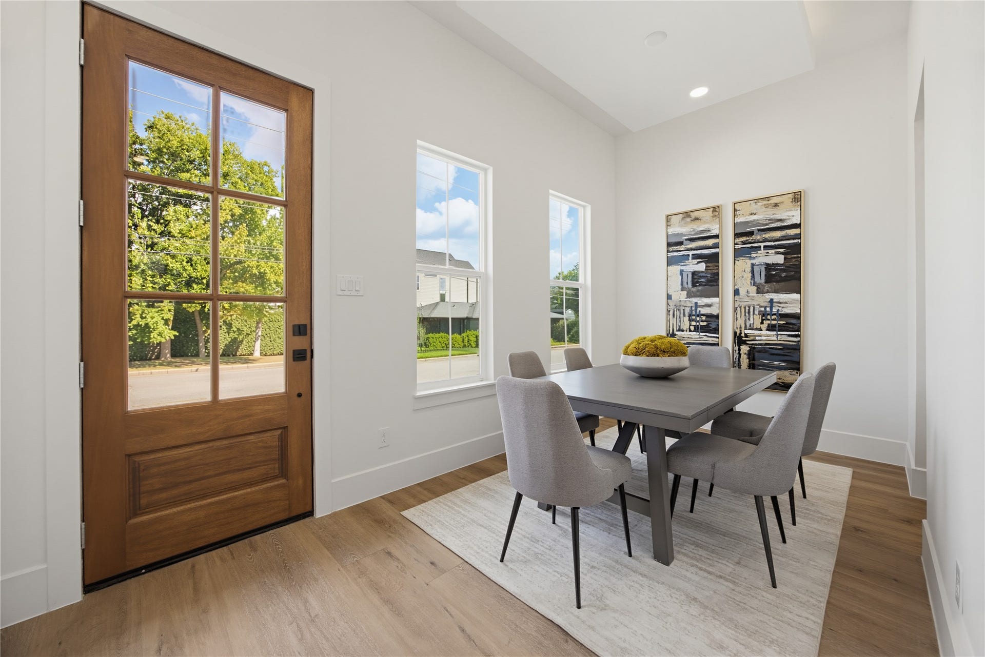 1004 E 35th Street, Houston, TX 77022 Bright and cozy dining area complemented by large windows and a stylish wooden door, creating a welcoming atmosphere.