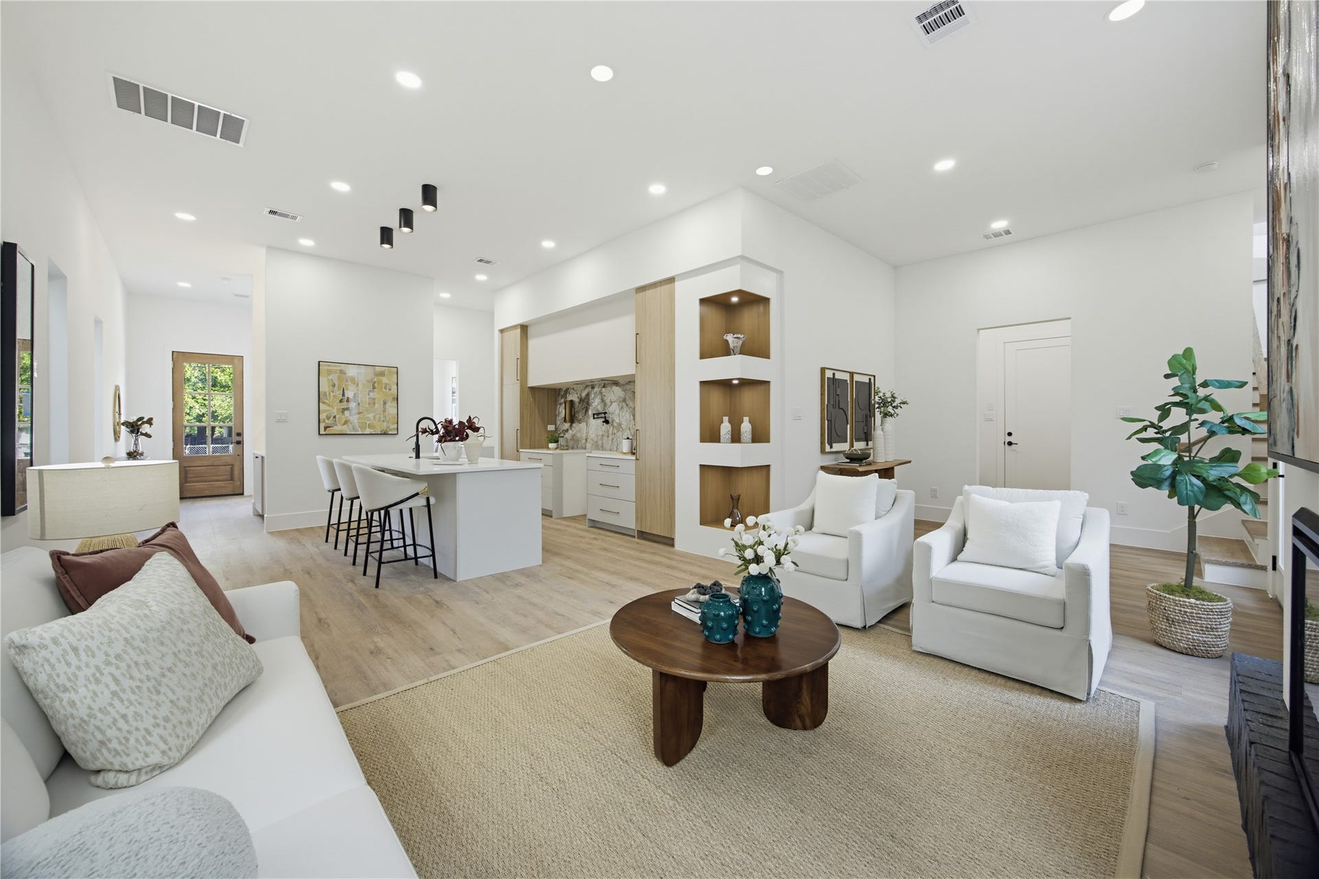 1004 E 35th Street, Houston, TX 77022 Spacious and modern open-concept living area with sleek hardwood floors, recessed lighting, and a stylish kitchen featuring a large island and contemporary finishes. Perfect for entertaining and relaxation.