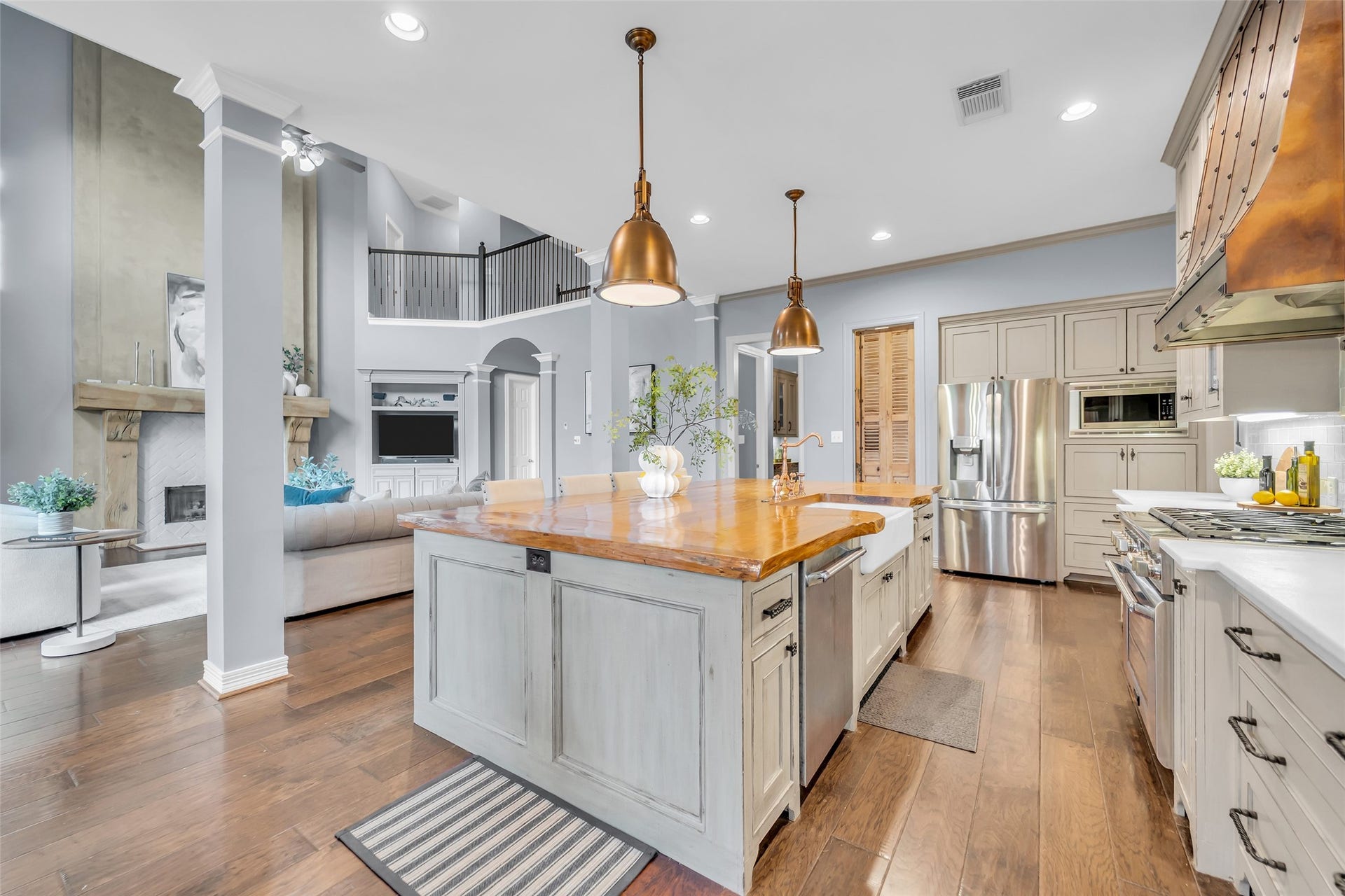 8703 Stones Throw Lane, Missouri City, TX 77459 Kitchen features stainless steel appliances, Thermador dishwasher, 6-burner Thermador range, ceramic farmhouse sink, copper faucet and sprayer, engineered wood and crown molding.