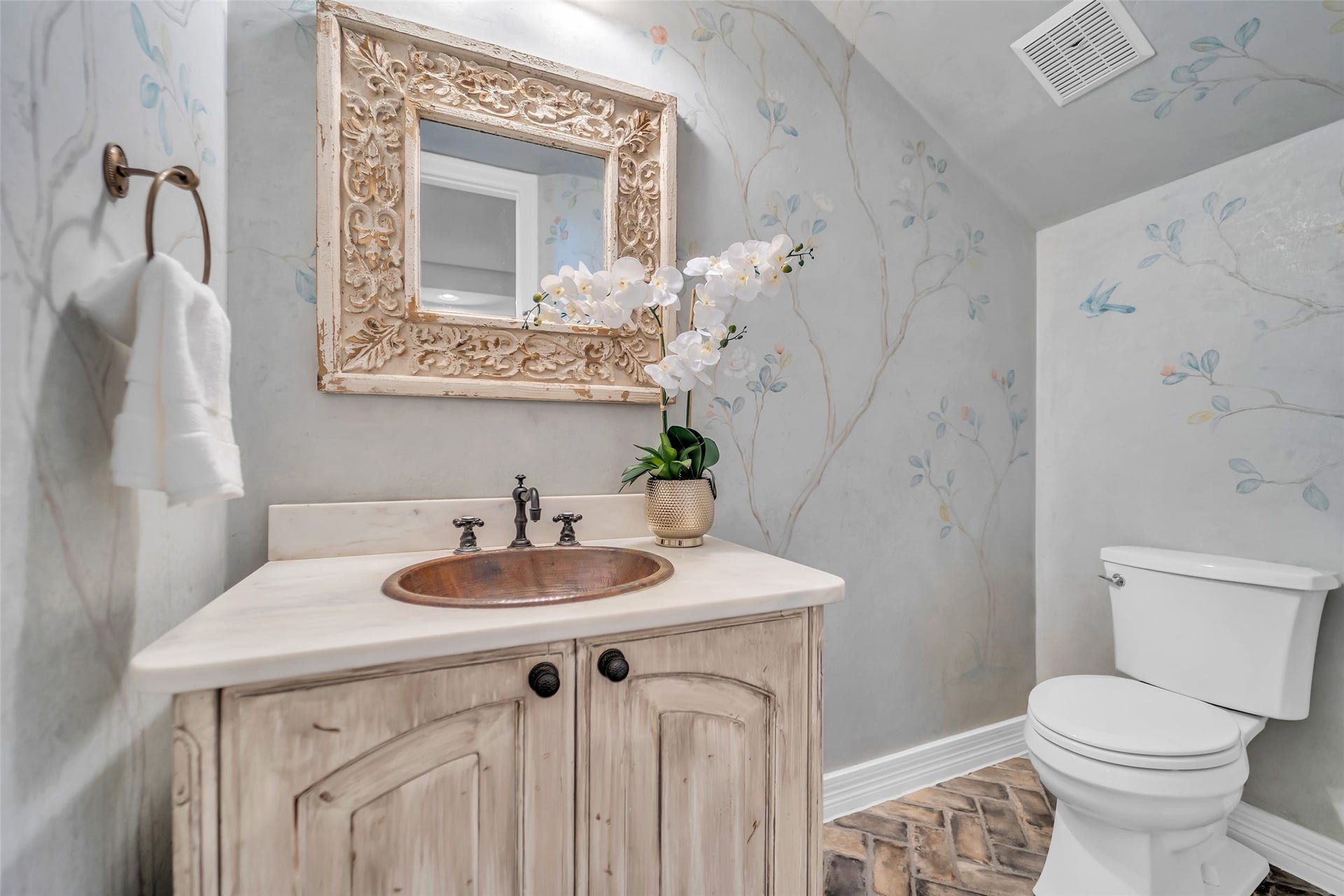 8703 Stones Throw Lane, Missouri City, TX 77459 Charming guest half bath with hand painted plaster walls, custom framed mirror, copper sink, honed marble countertop and brick flooring.