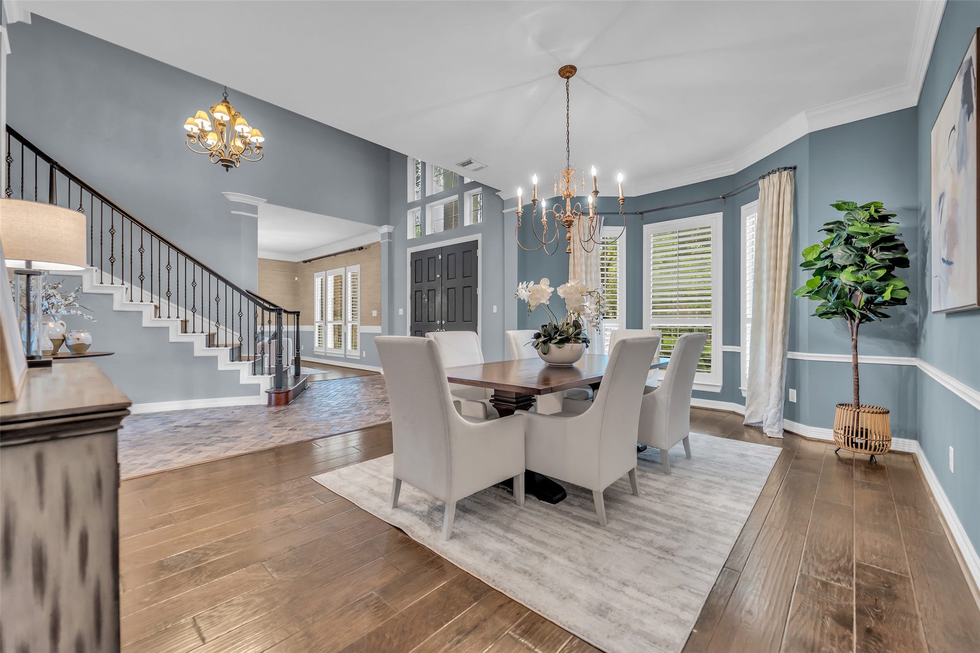 8703 Stones Throw Lane, Missouri City, TX 77459 A formal dining room, perfect for entertaining with a custom chandelier, engineered wood floors, double crown molding, chair railing, and windows with plantation shutters.