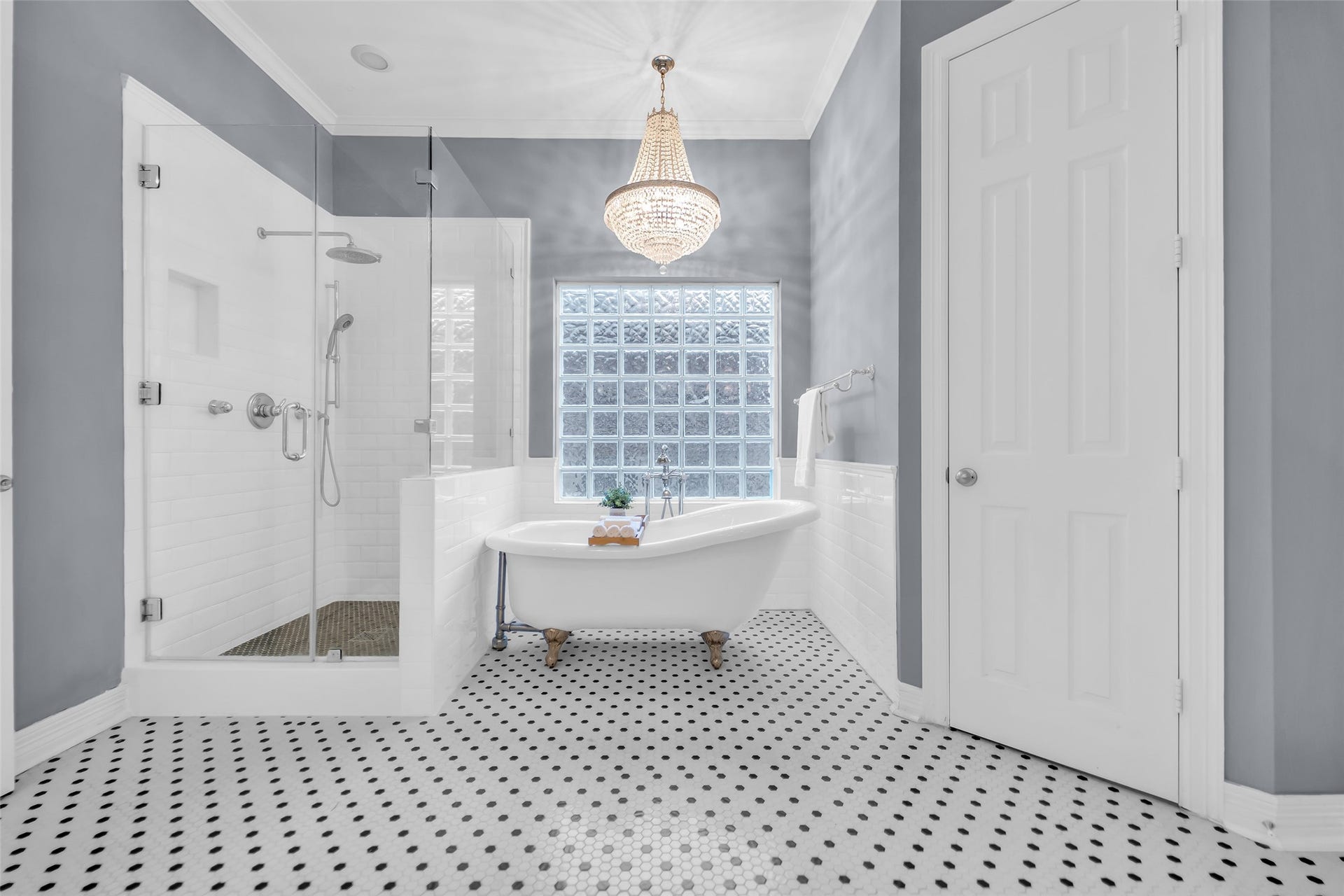 8703 Stones Throw Lane, Missouri City, TX 77459 Ensuite primary bathroom with hexagon tile flooring, clawfoot tub, seamless glass shower and stunning chandelier!