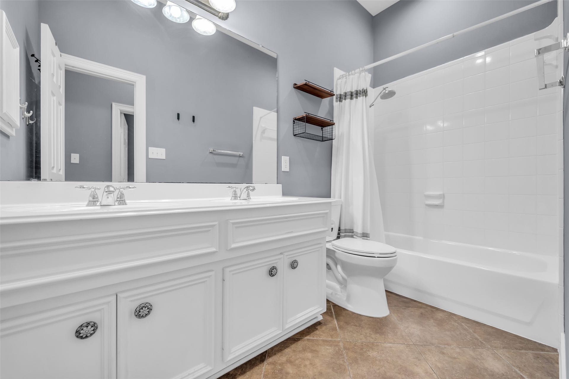8703 Stones Throw Lane, Missouri City, TX 77459 Upstairs hall bath features cultured marble countertop with double sinks, medicine cabinet, tub-shower, tile shower surround and tile flooring.