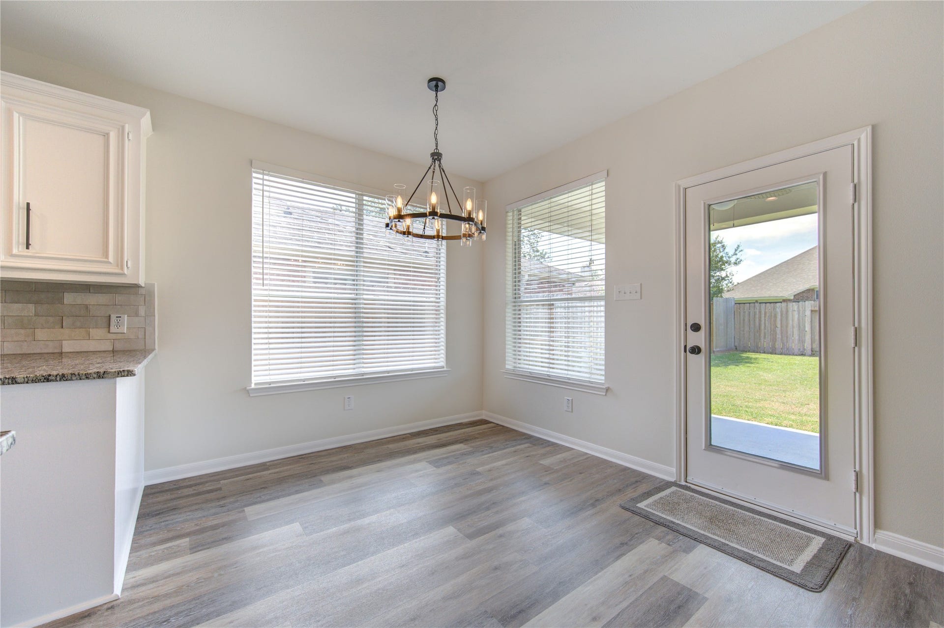20911 Golden Sycamore Trail, Cypress, TX 77433 Bright breakfast room with two large windows providing abundant natural light, a beautiful new wagon-wheel chandelier, and direct access to the spacious covered back patio.