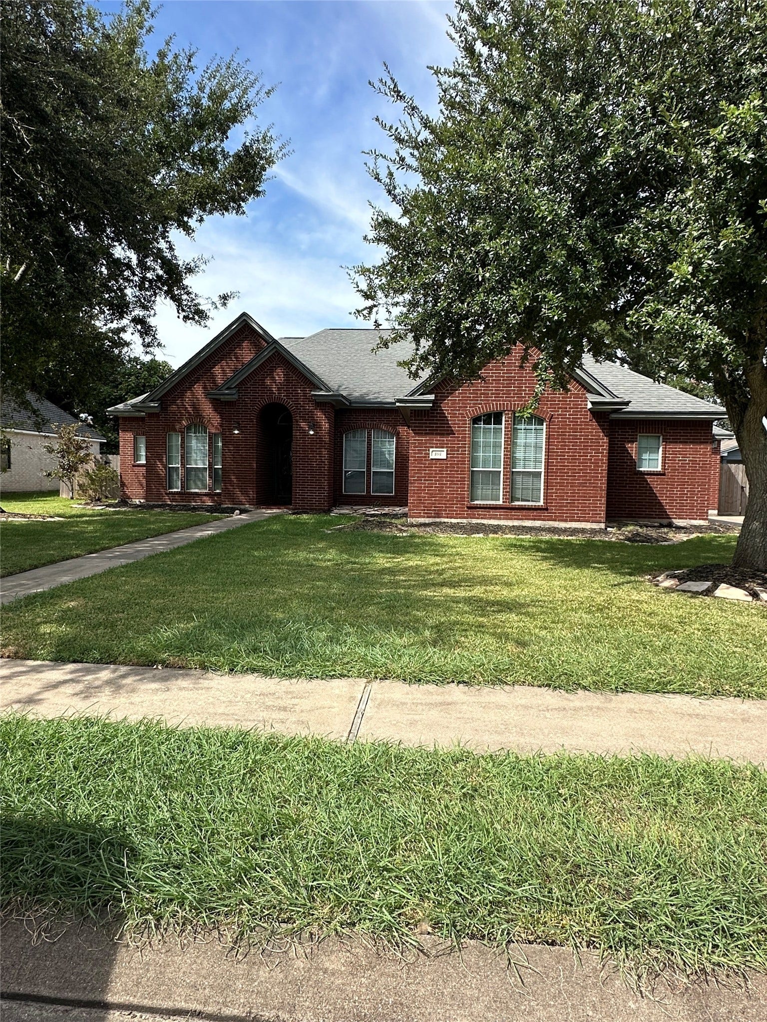 101 Mallard Drive, Clute, TX 77531 Beautifully landscaped backyard featuring a sprawling lawn and mature shade trees, perfect for outdoor enthusiasts and relaxation.