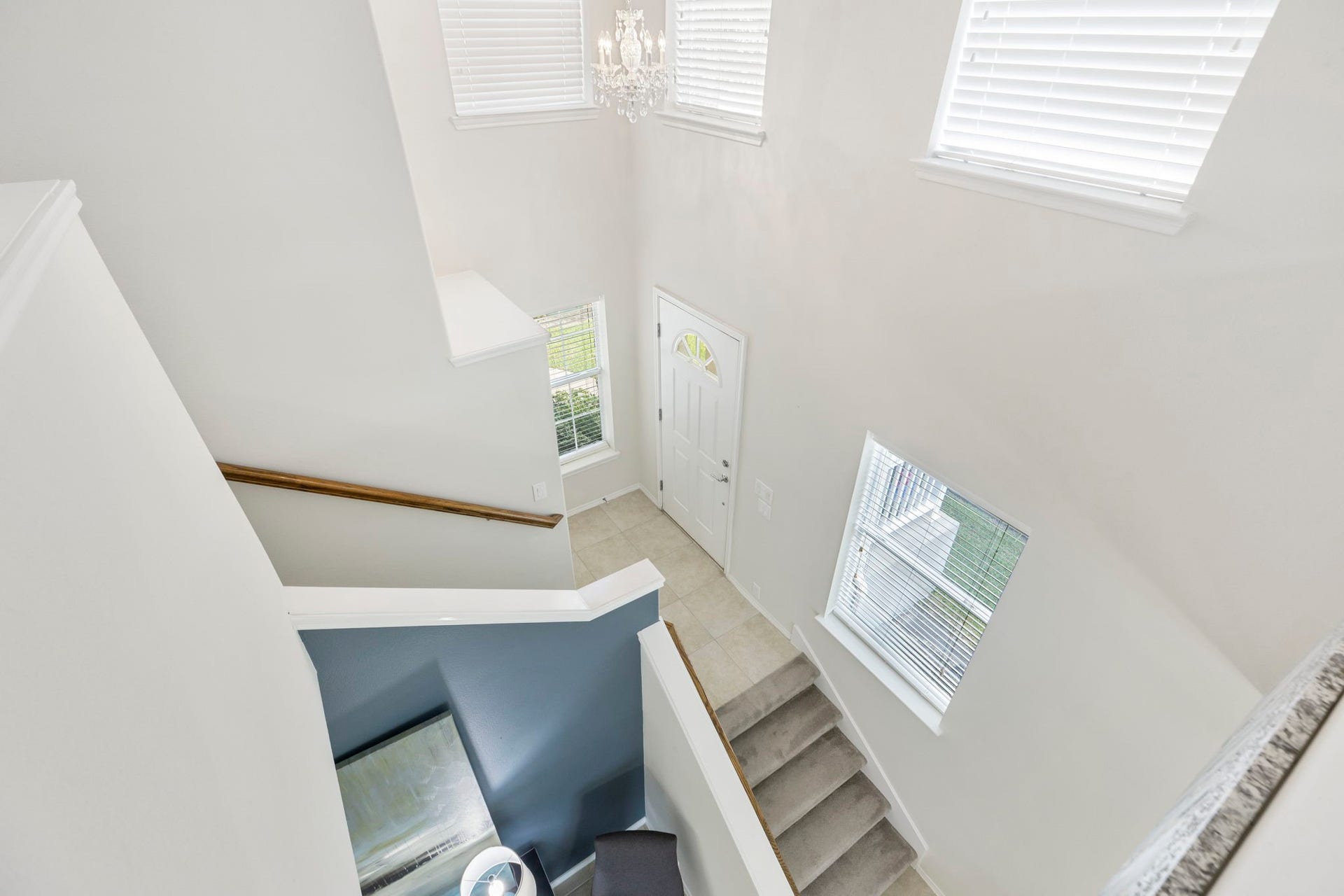 13600 Breton Ridge Street, #11A, Houston, TX 77070 The bright and airy staircase with high ceilings, large windows, and elegant chandelier makes a grand first impression.