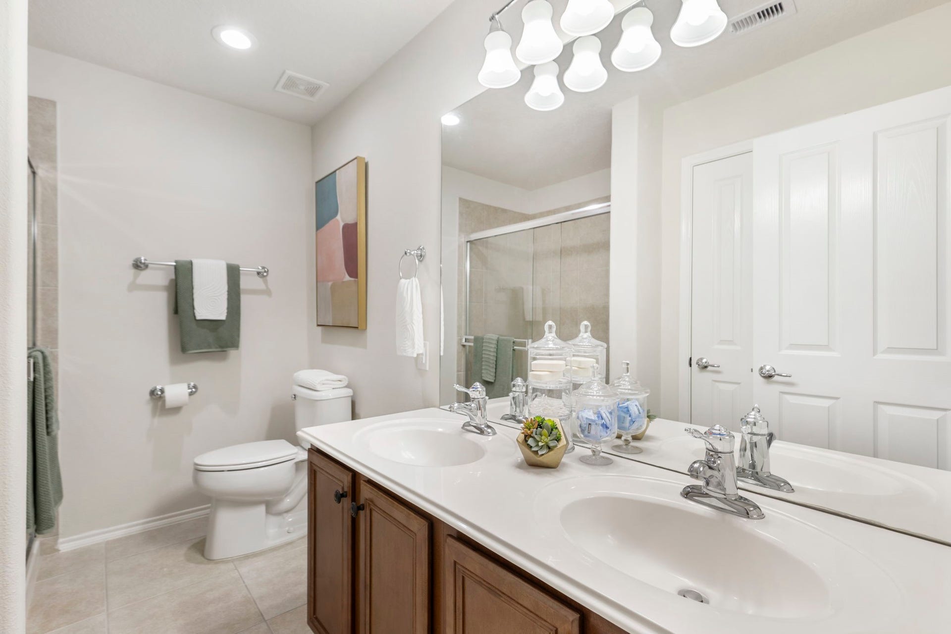 13600 Breton Ridge Street, #11A, Houston, TX 77070 Your primary bathroom features a wide vanity with dual sinks, elegant fixtures, LED lighting, rich wood cabinetry and a generously sized storage closet.