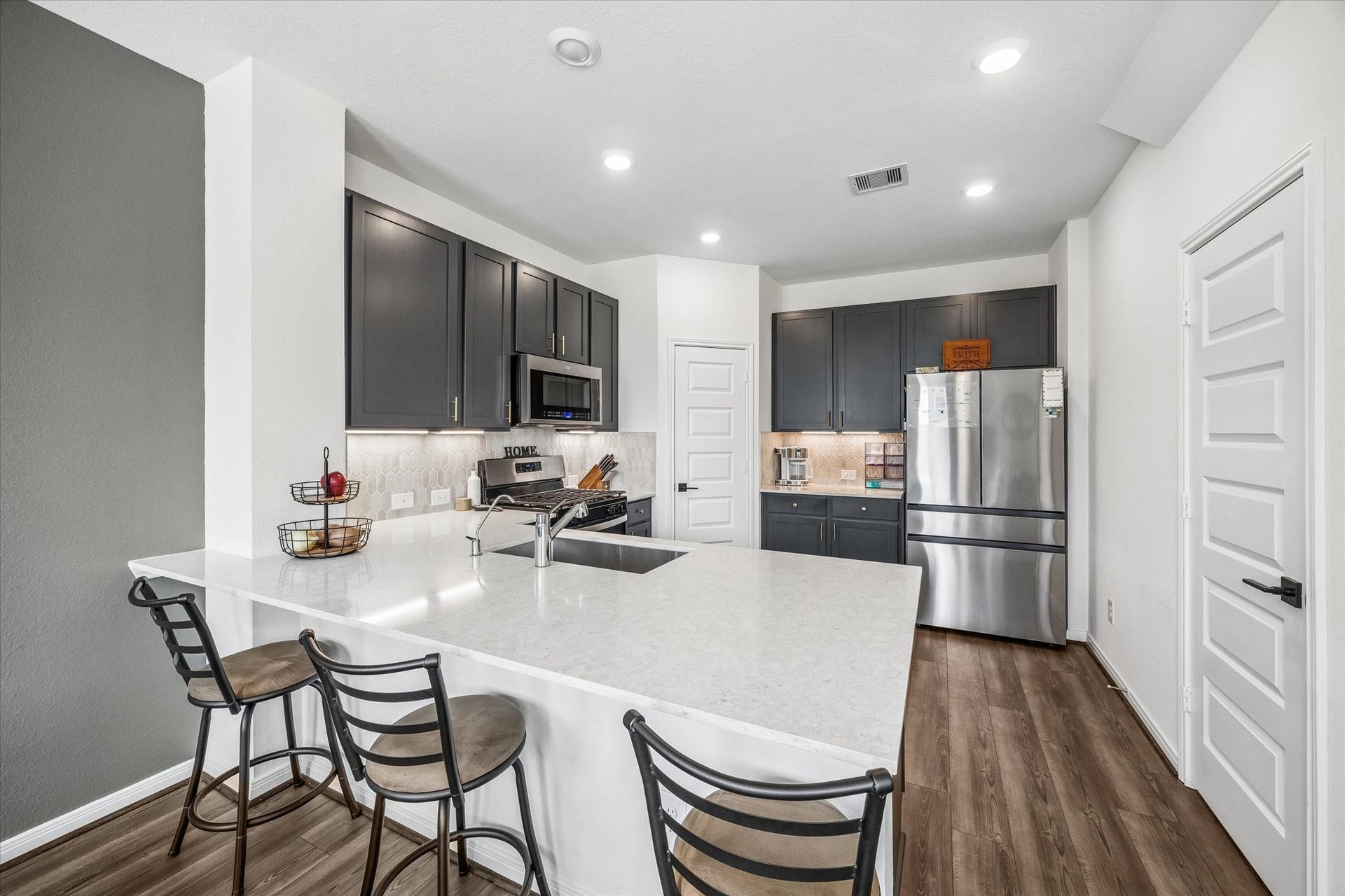 2852 Grand Anse Drive, Katy, TX 77493 Modern kitchen featuring rich cabinetry, stainless steel appliances, generous counter space, and a large island with bar seating for casual dining.