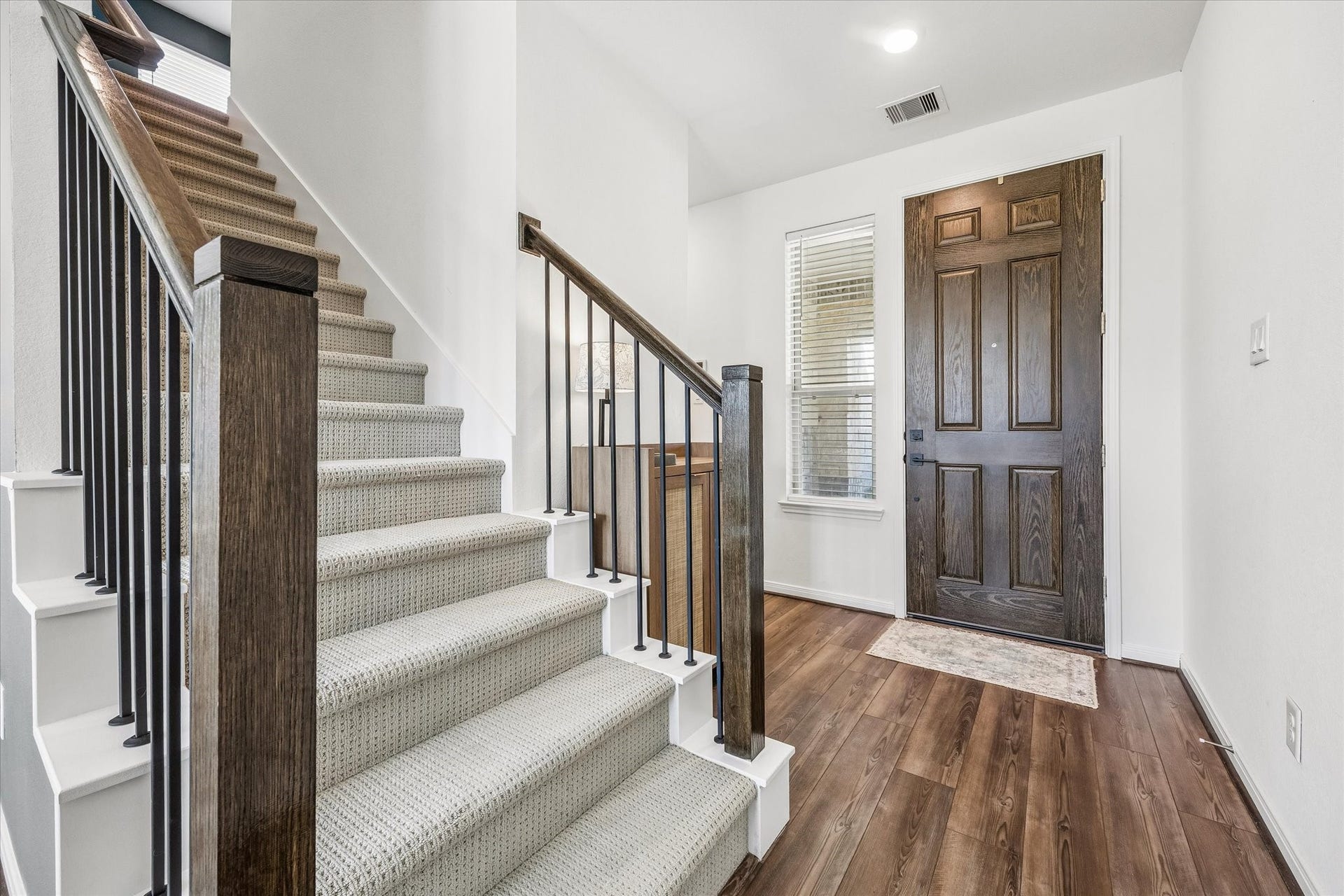 2852 Grand Anse Drive, Katy, TX 77493 Alternate view of the entryway highlighting the staircase, warm wood-look flooring, and natural light welcoming you into the home.