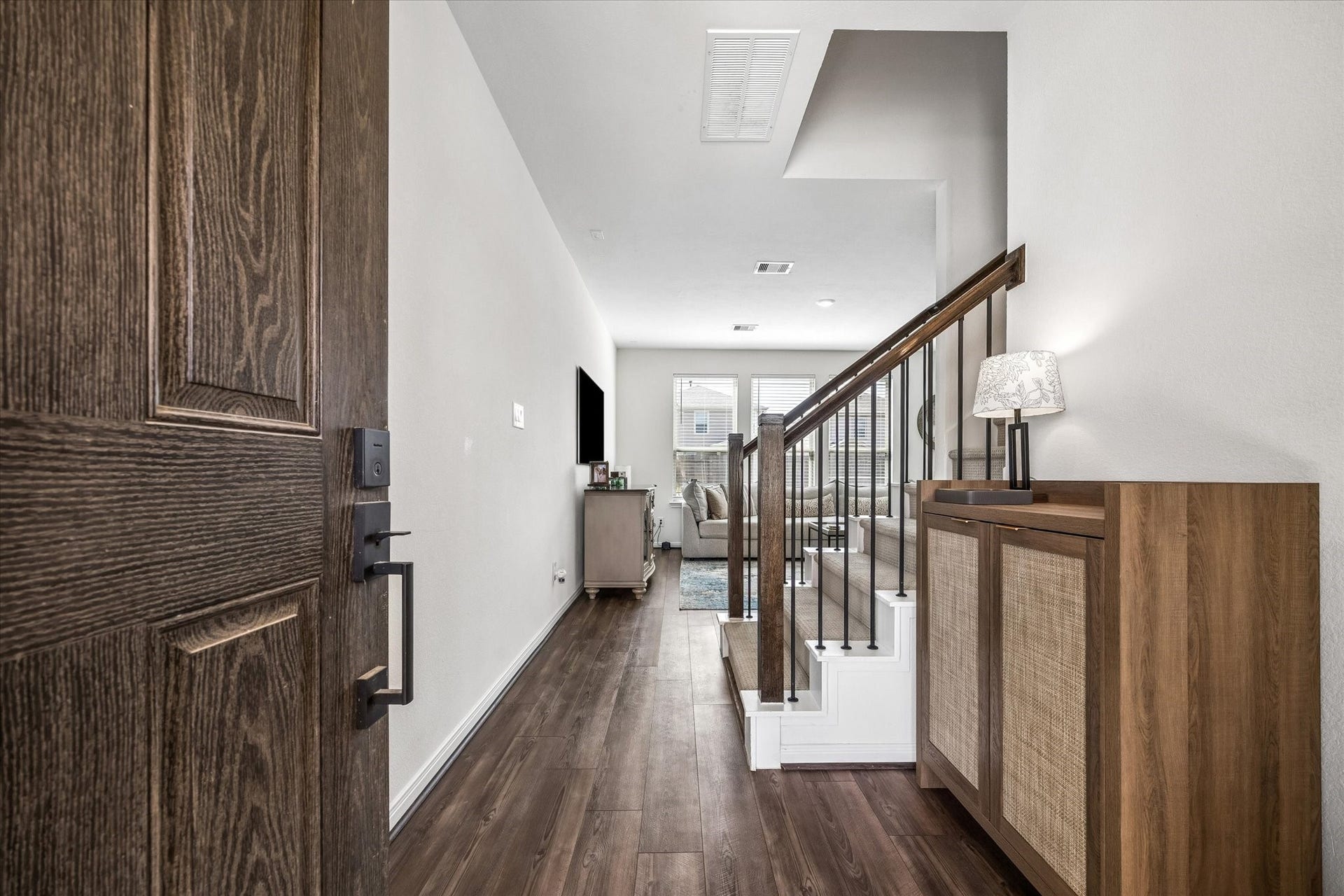 2852 Grand Anse Drive, Katy, TX 77493 Step inside to a welcoming entryway featuring warm wood-look flooring and a staircase with rich wood accents, opening into the heart of home.