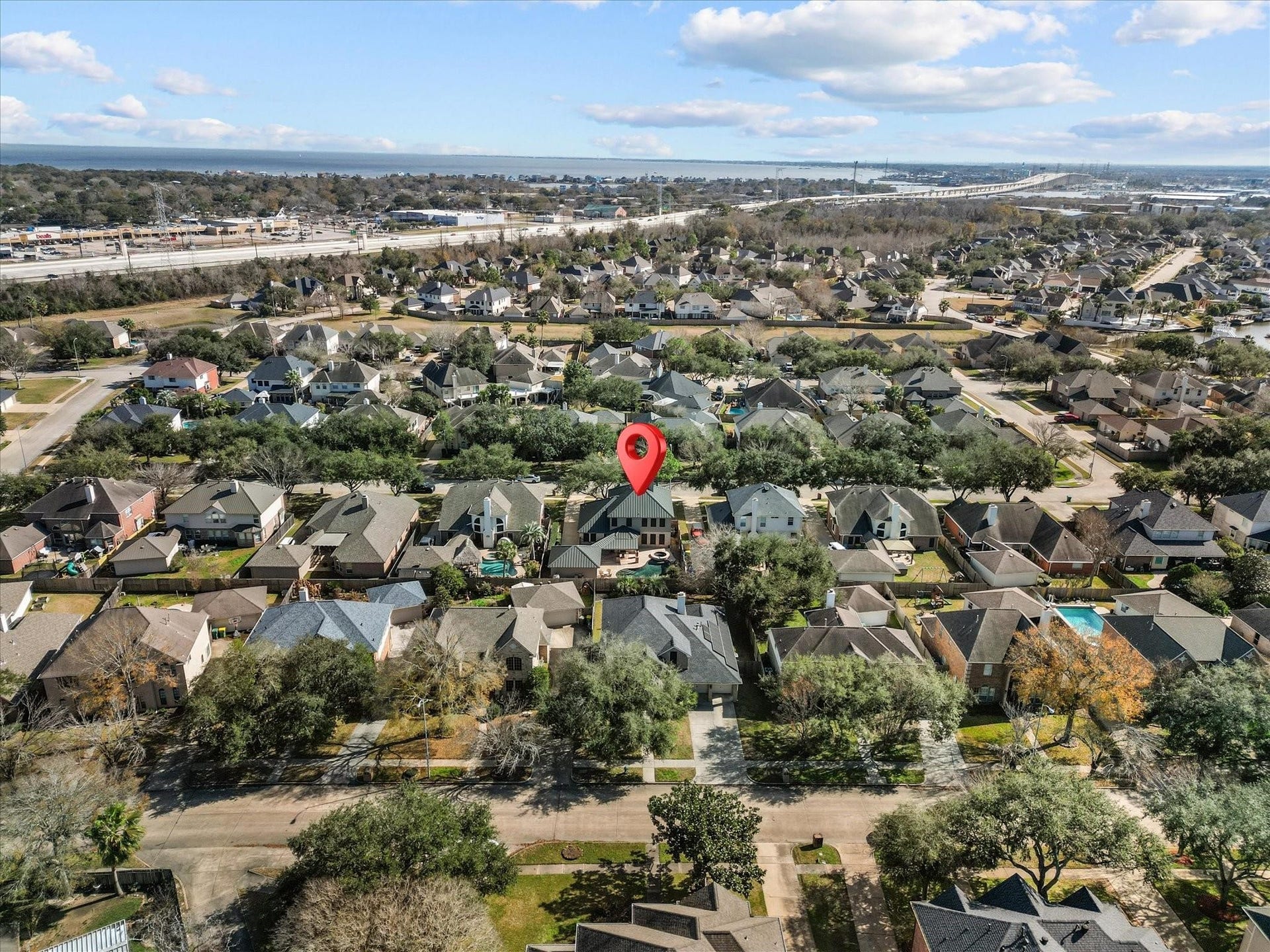 2437 La Rochelle Court, Seabrook, TX 77586 Aerial perspective shows the surrounding residential neighborhood and nearby bay shoreline.