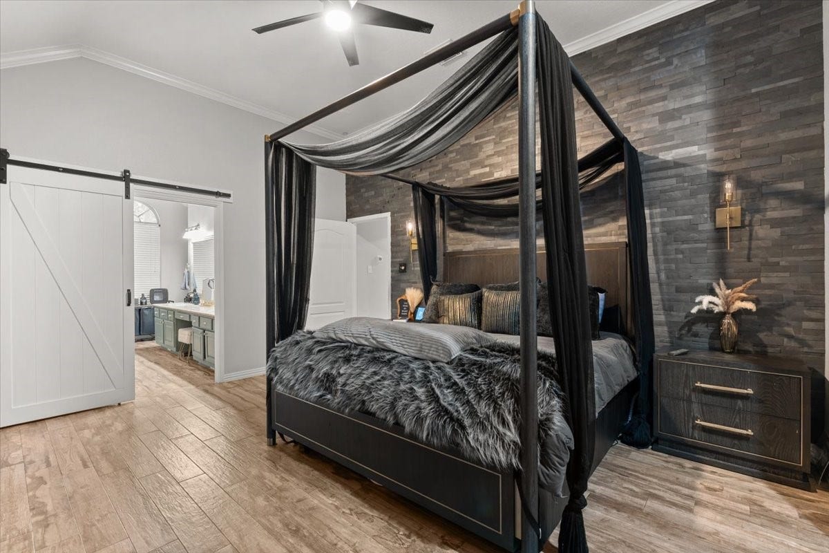 2437 La Rochelle Court, Seabrook, TX 77586 Additional primary bedroom view highlights the stone accent wall and barn-style bathroom door.