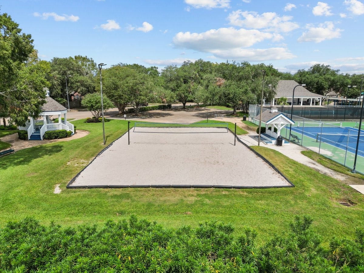2437 La Rochelle Court, Seabrook, TX 77586 Community recreation area includes a sand volleyball court beside sports courts and green space.