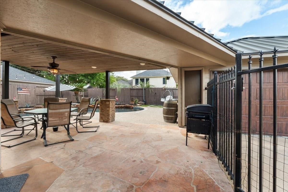 2437 La Rochelle Court, Seabrook, TX 77586 Covered outdoor entertaining area provides a sheltered dining space just steps from the pool.