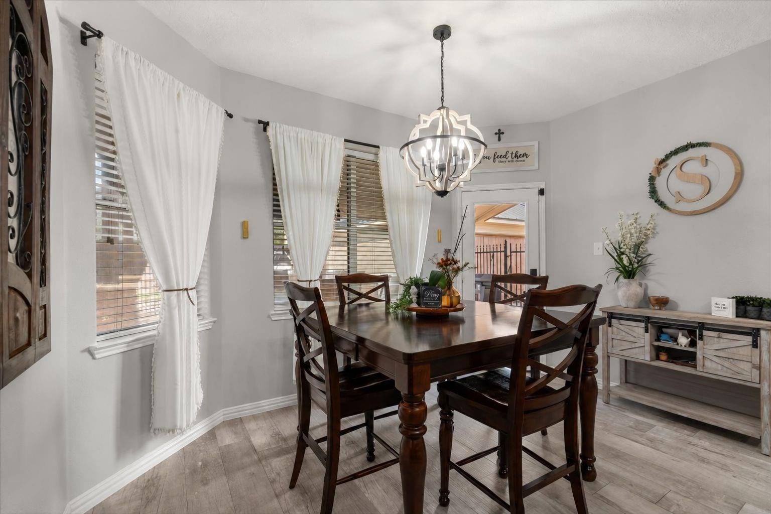 2437 La Rochelle Court, Seabrook, TX 77586 Bay windows and a statement chandelier bring light and charm to the everyday dining area.