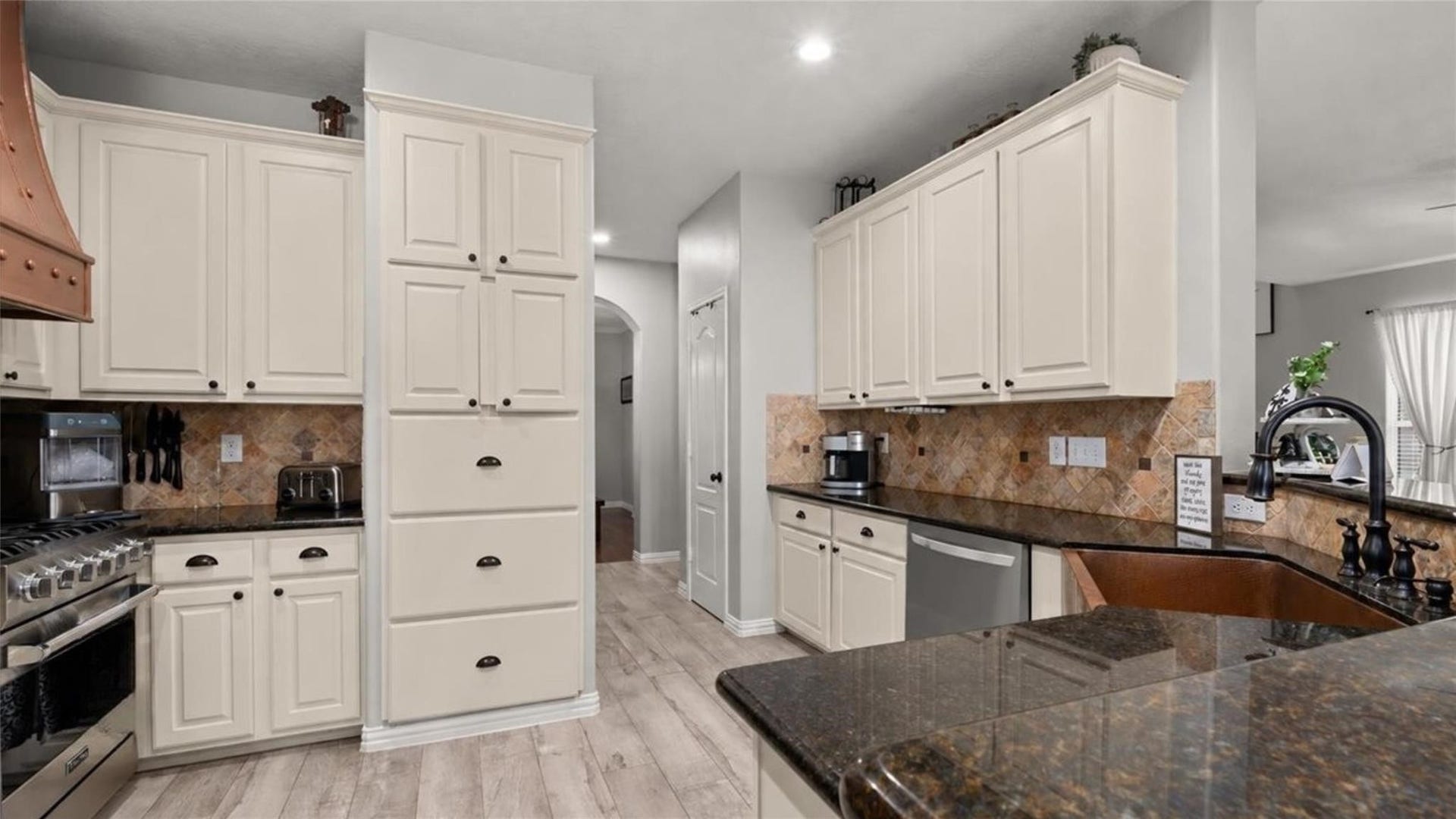 2437 La Rochelle Court, Seabrook, TX 77586 Generous cabinetry, granite countertops, and stainless steel appliances provide a practical cooking workspace.