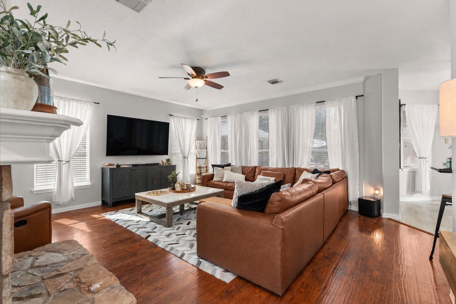 2437 La Rochelle Court, Seabrook, TX 77586 Natural light brightens this spacious living area with wood flooring and large windows.