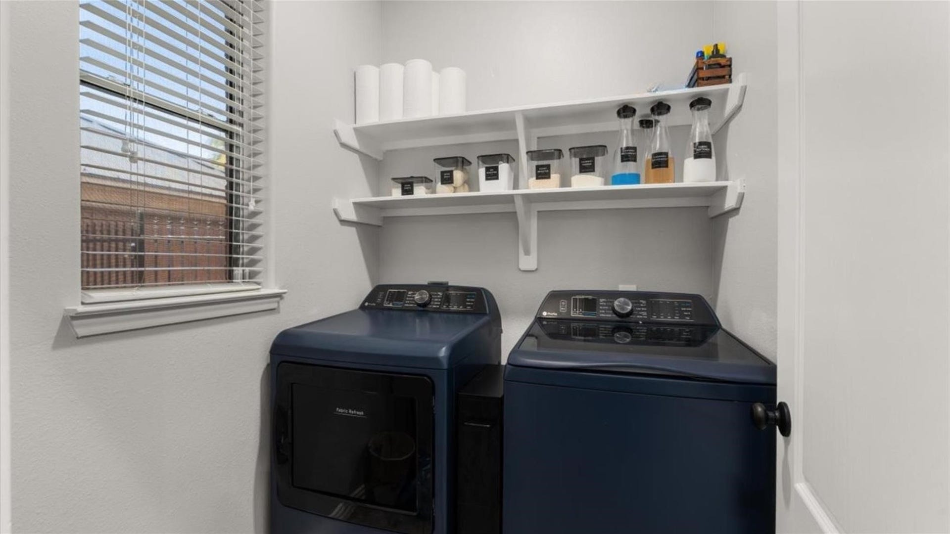2437 La Rochelle Court, Seabrook, TX 77586 Laundry room offers a window for natural light and built-in overhead storage shelves.