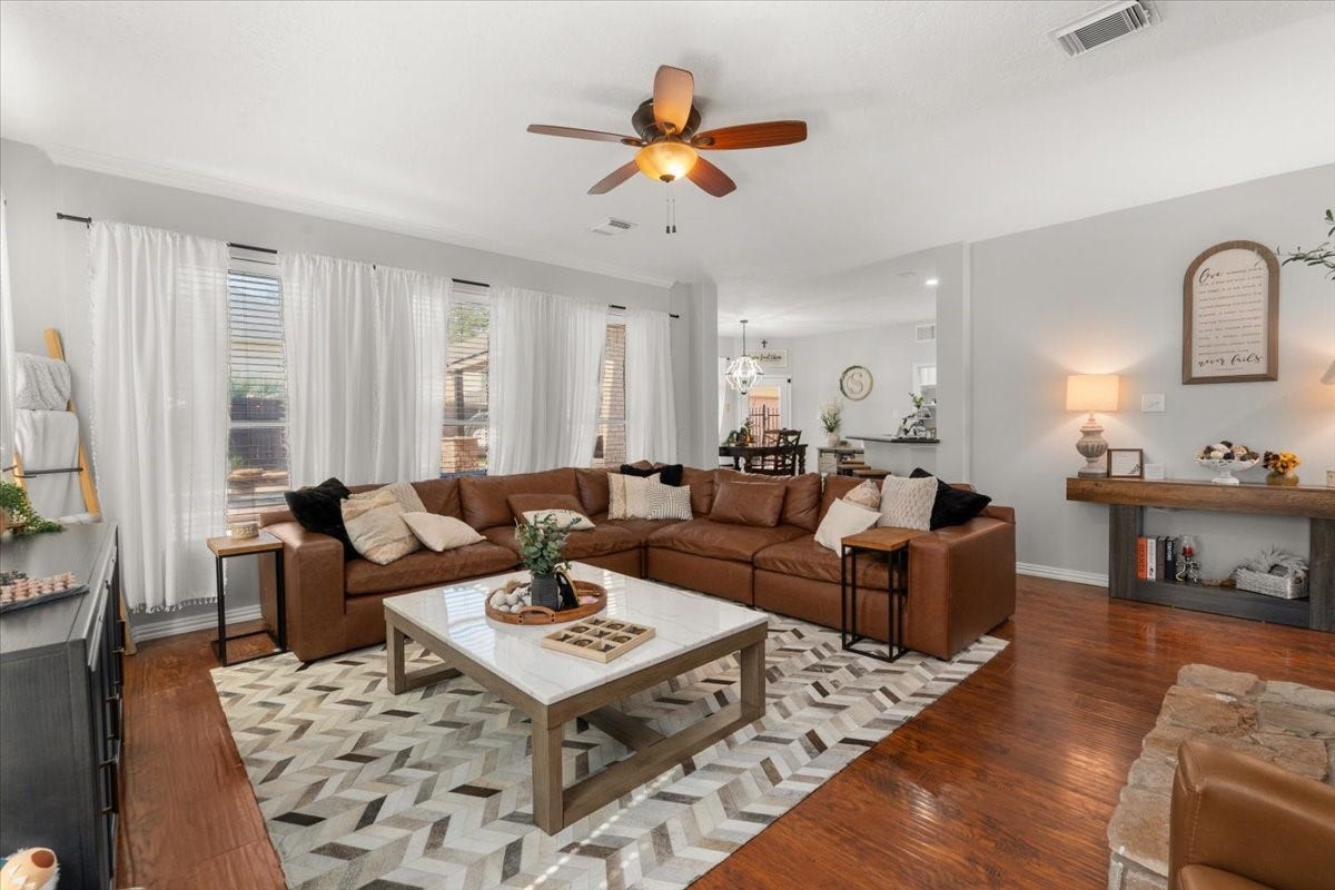 2437 La Rochelle Court, Seabrook, TX 77586 An expansive family room with wood flooring opens toward the breakfast area and kitchen.