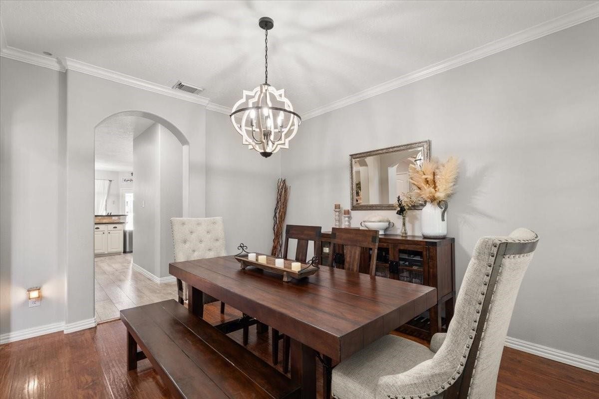 2437 La Rochelle Court, Seabrook, TX 77586 The dining room offers a spacious setting for gatherings and an arched opening to the home beyond.