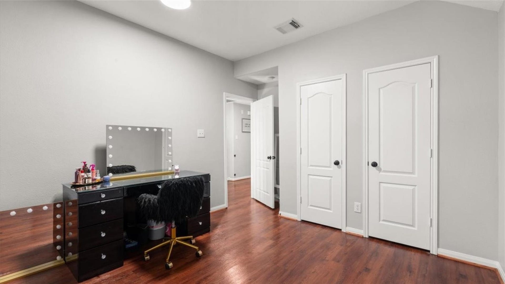 2437 La Rochelle Court, Seabrook, TX 77586 Secondary bedroom with neutral walls, wood flooring, and closet access offers flexible possibilities.