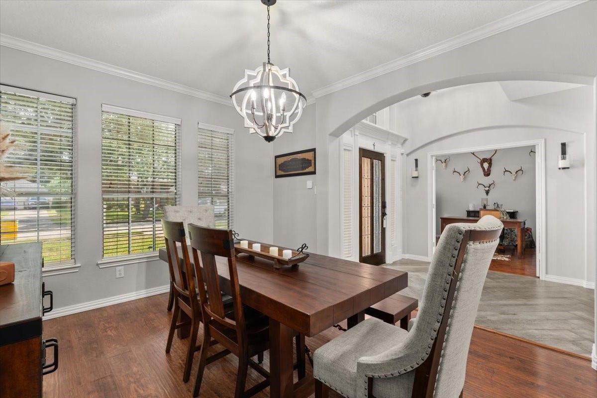 2437 La Rochelle Court, Seabrook, TX 77586 Formal dining room features wood flooring, crown molding, and an eye-catching chandelier.