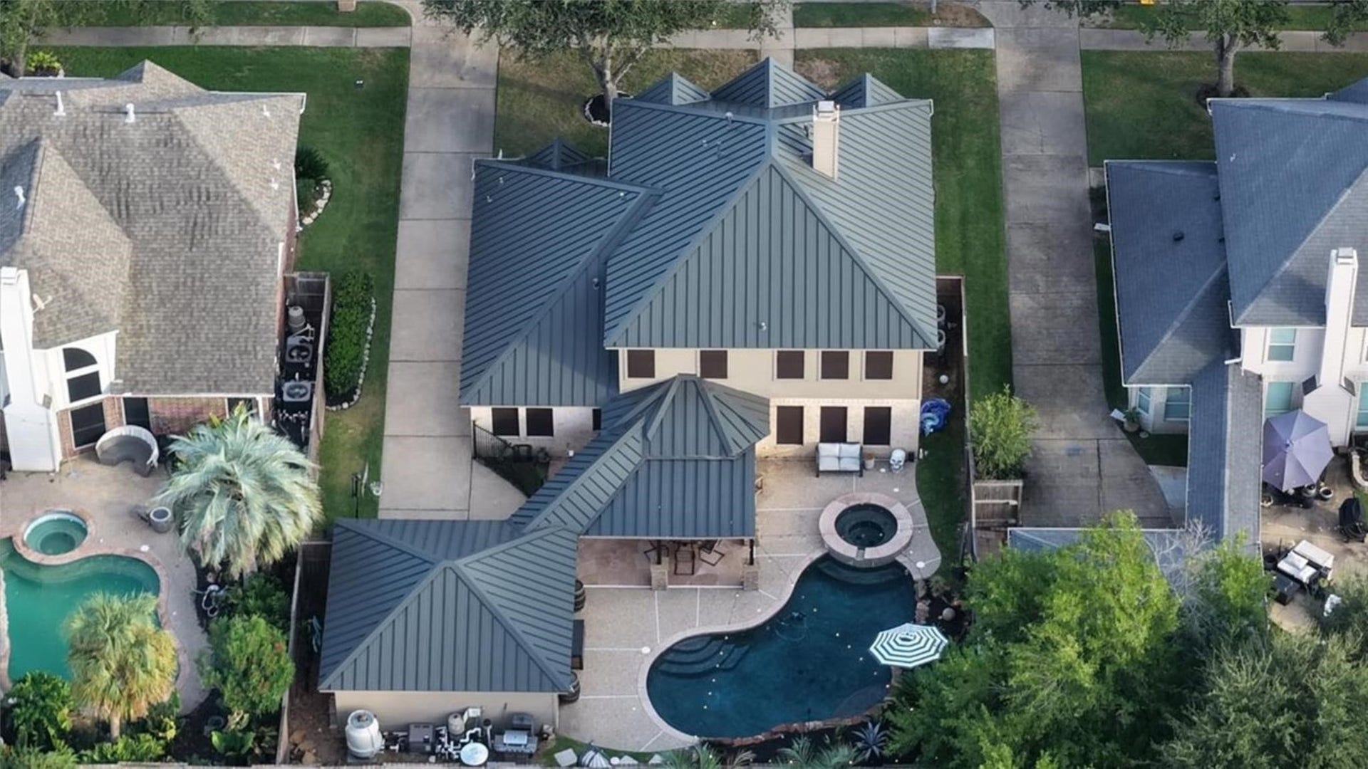 2437 La Rochelle Court, Seabrook, TX 77586 Overhead view highlighting the distinctive metal roof, backyard pool, raised spa, and covered patio.