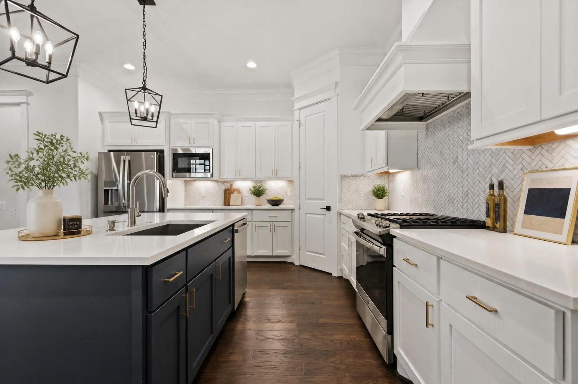 1128 Malone Street, Houston, TX 77007 The kitchen makes a strong impression with quartz countertops, a large island, gas cooktop, custom vent hood, under-cabinet lighting, and stainless steel appliances. It feels sharp, open, and designed for everyday function. Virtually staged.