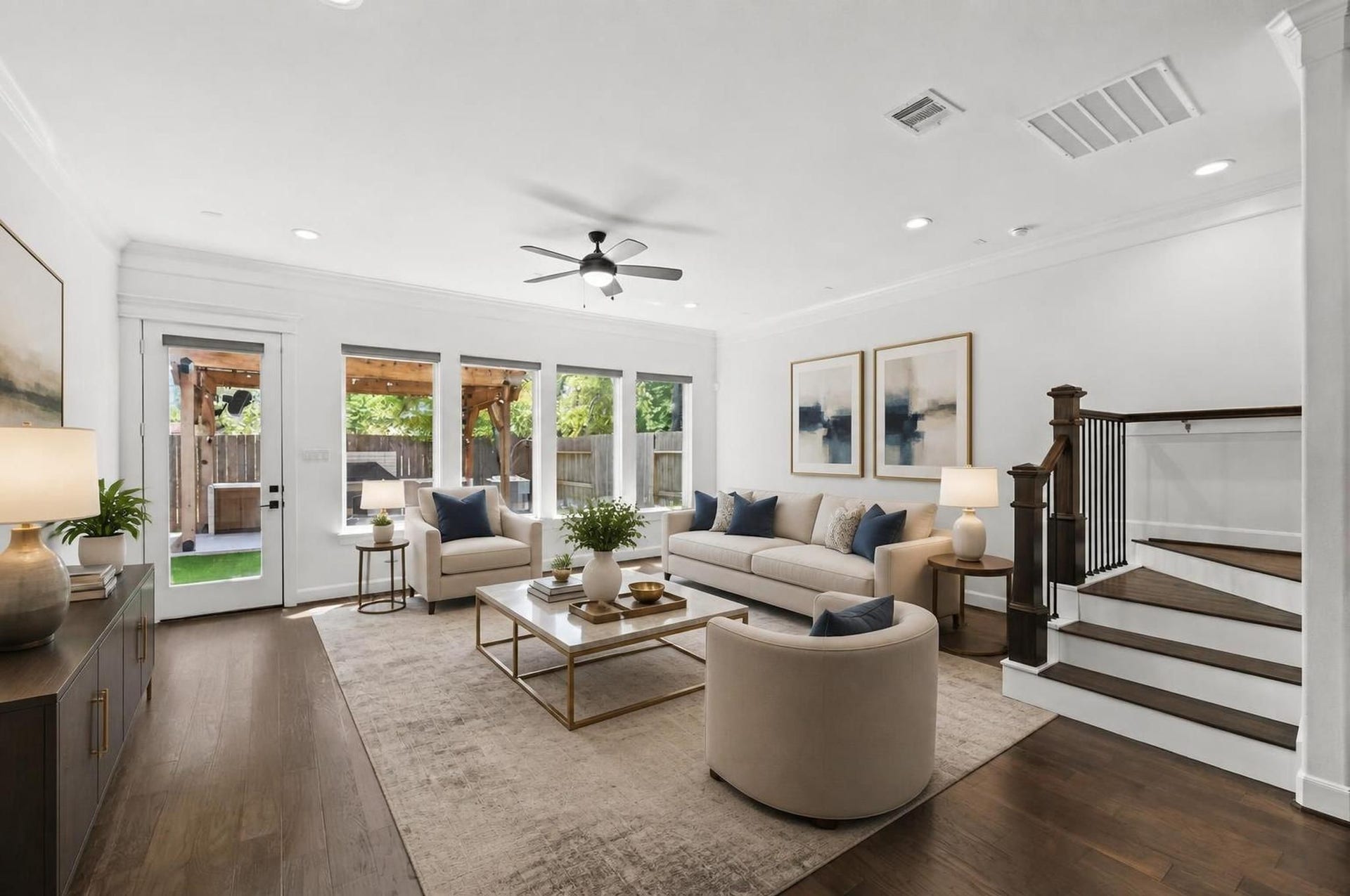 1128 Malone Street, Houston, TX 77007 The living room opens toward the backyard with wide windows and an easy connection to the staircase and kitchen. The space feels bright, open, and designed around everyday gathering. Virtually staged.