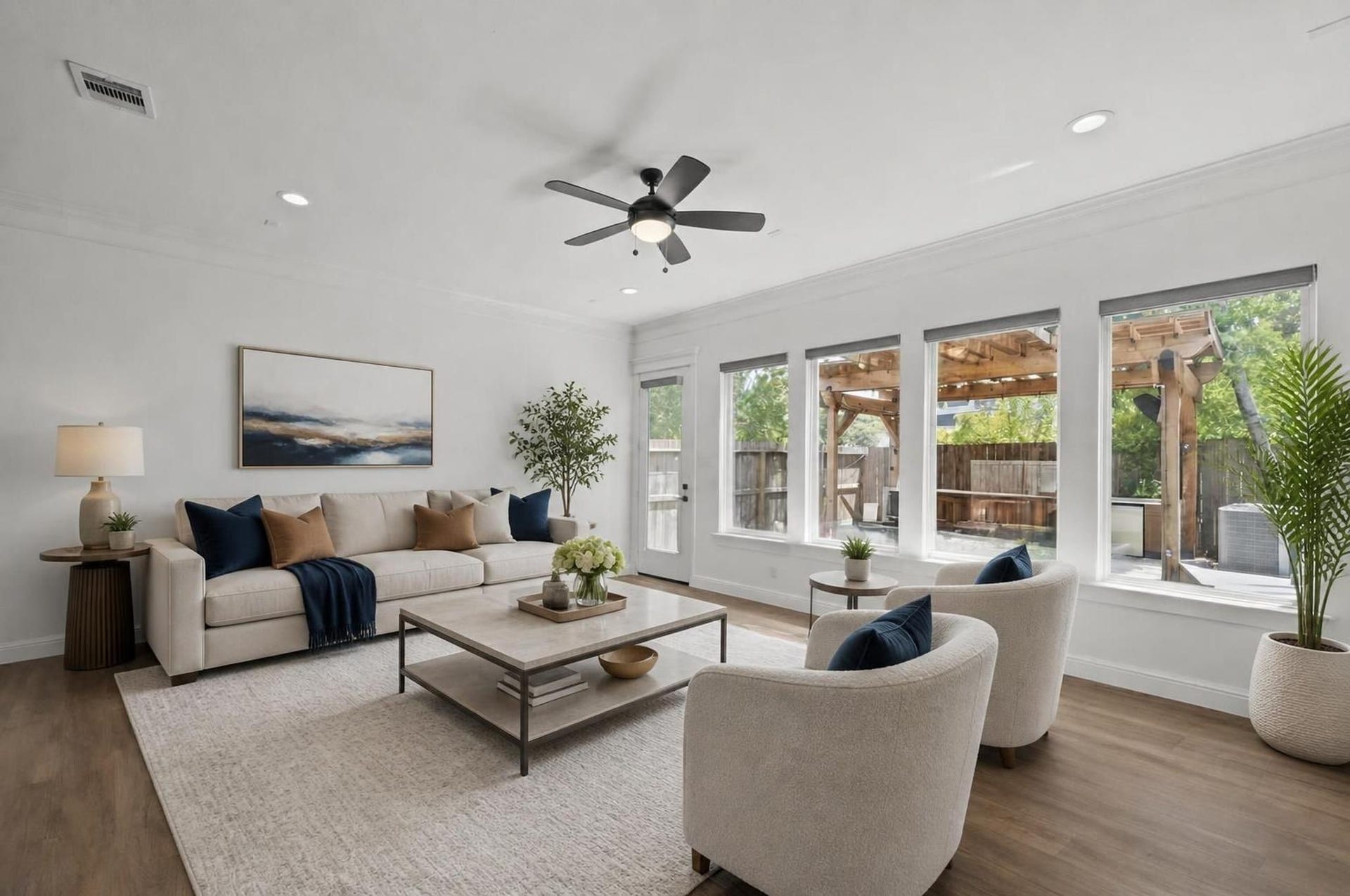 1128 Malone Street, Houston, TX 77007 The living room opens with engineered wood floors, crown molding, oversized windows, and strong natural light. The space connects directly to the kitchen and dining area for true first-floor living. Virtually staged.