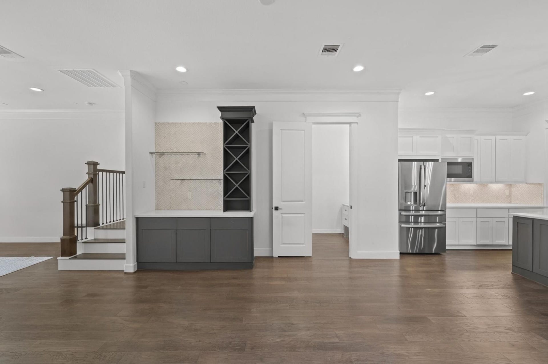 1128 Malone Street, Houston, TX 77007 The custom dry bar adds a polished detail with cabinetry, shelving, and a wine fridge. It gives the main level a more elevated entertaining feature.
