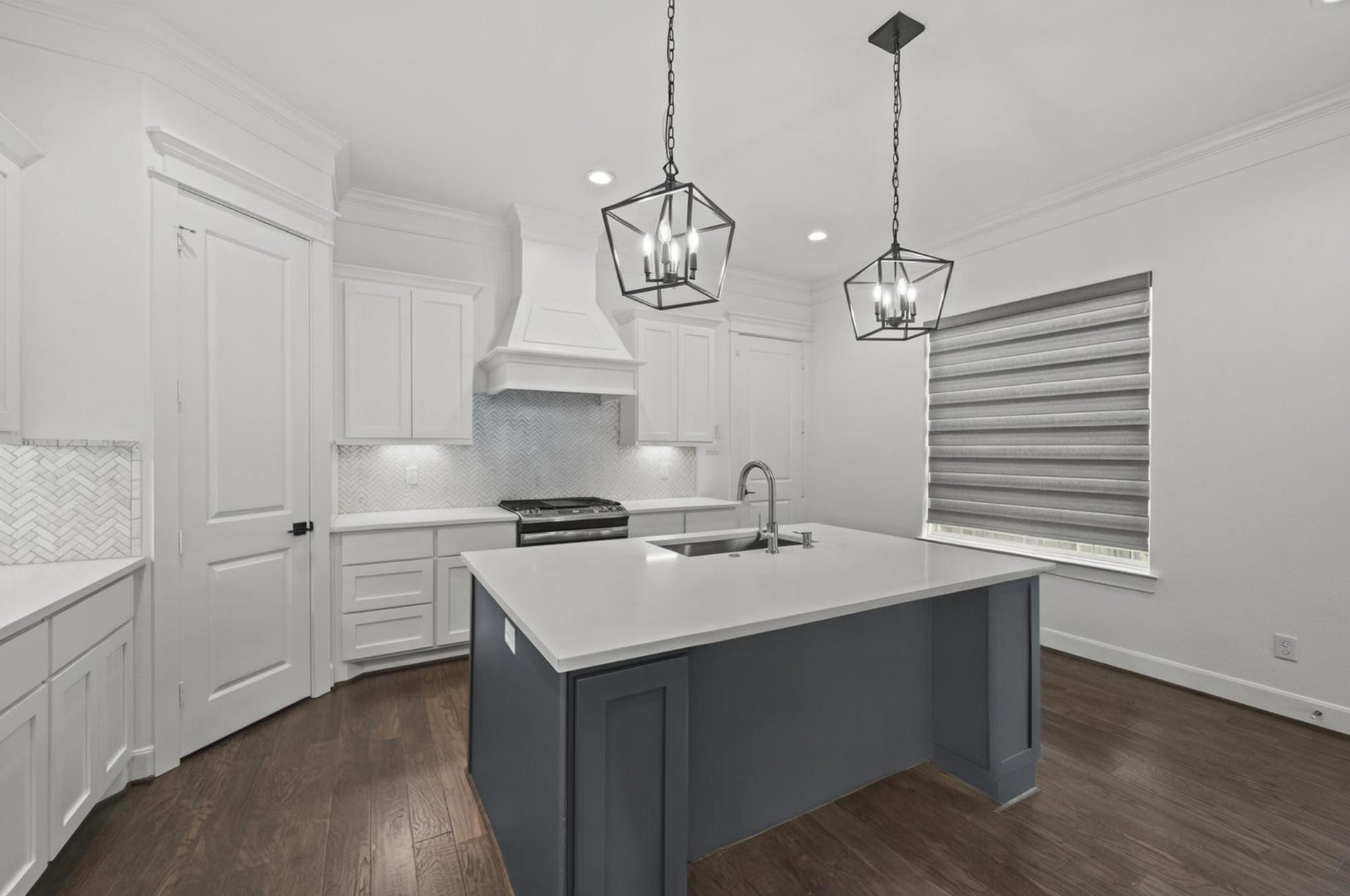 1128 Malone Street, Houston, TX 77007 The kitchen island creates the centerpiece of the main level with seating, prep space, and a clean visual connection to the rest of the home. Pendant lighting and quartz surfaces give the space a polished finish.