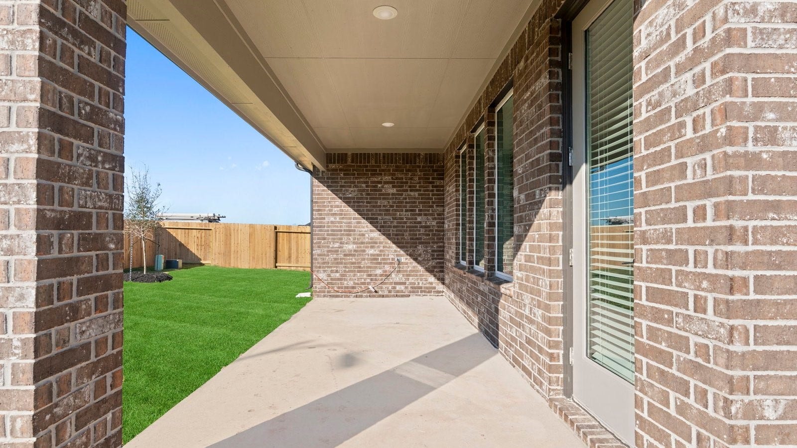 14028 Pine Cliffs Drive, Texas City, TX 77568 Outdoor covered patio with seating area overlooking a well-maintained lawn, perfect for relaxation.