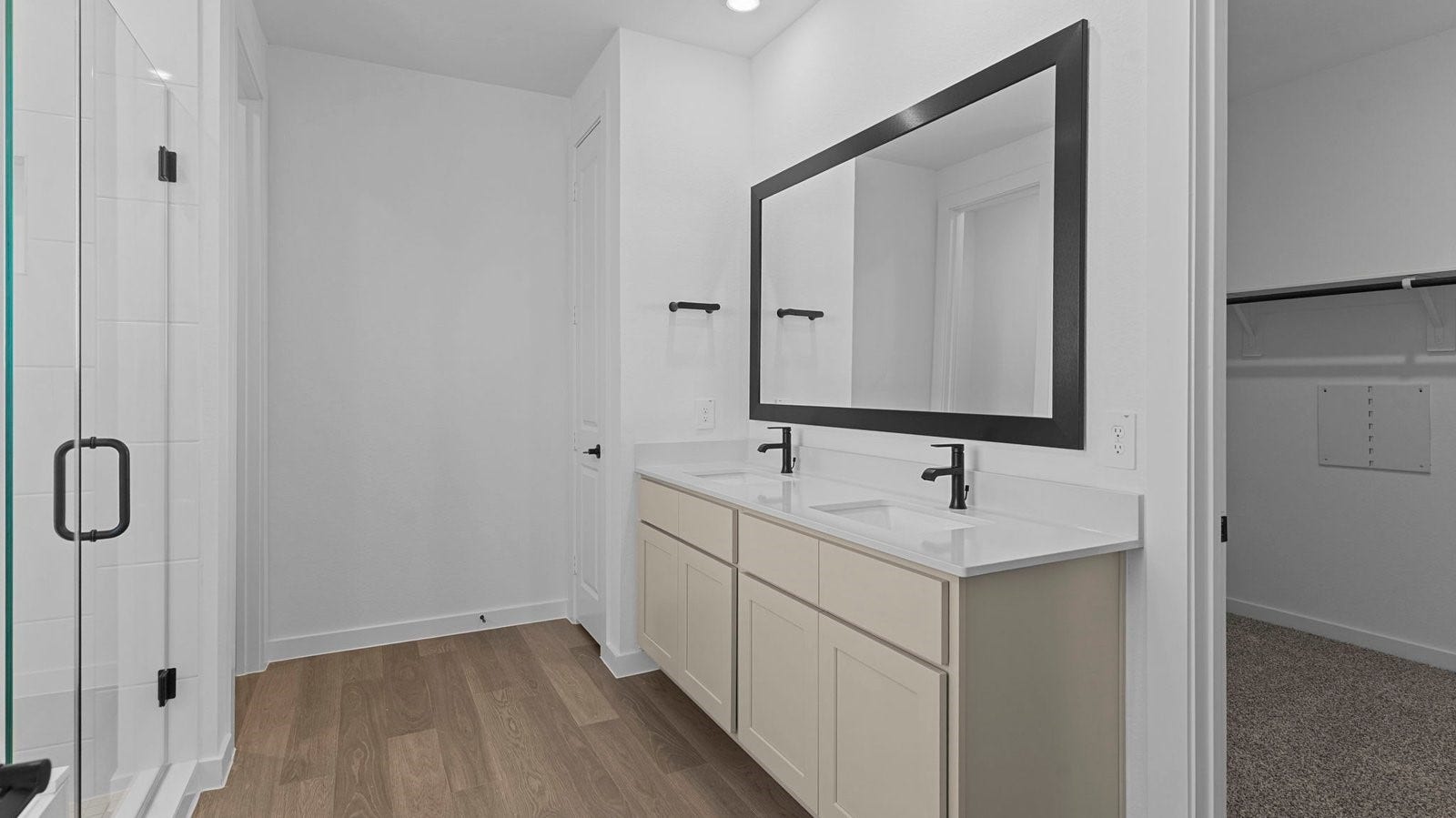 14028 Pine Cliffs Drive, Texas City, TX 77568 Modern primary bathroom with double vanities, quartz countertops, and a glass-enclosed shower with a walk-in closet.