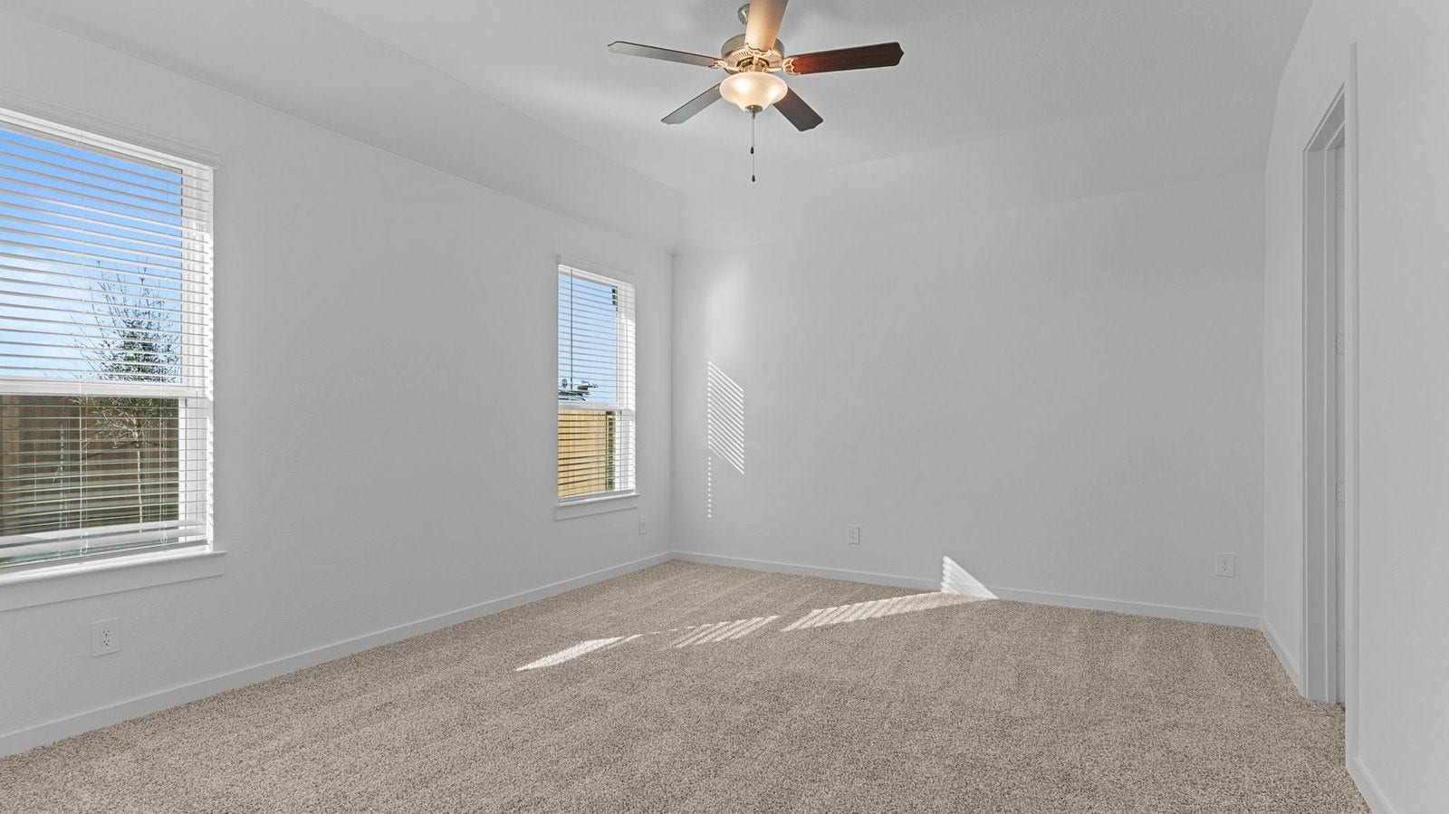 14028 Pine Cliffs Drive, Texas City, TX 77568 A spacious primary bedroom emphasizing open space and natural lighting with large windows.